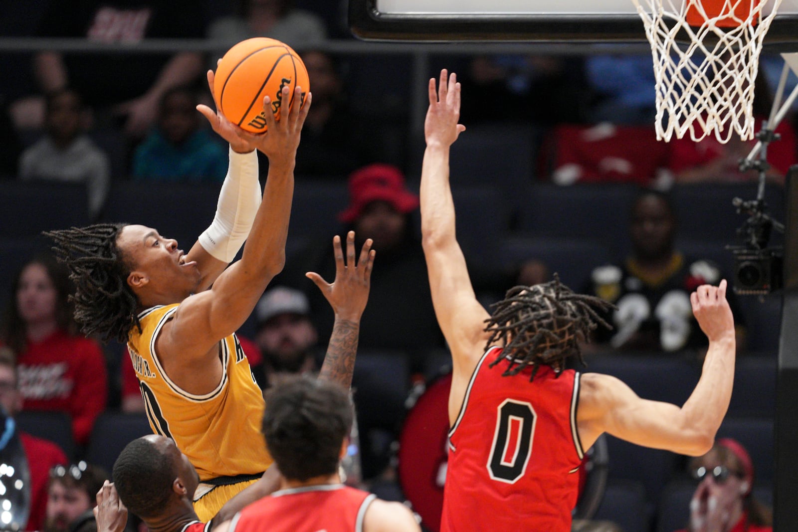 Alabama State guard TJ Madlock, left, shoots against Saint Francis' Chris Moncrief (0) during the first half of a First Four college basketball game in the NCAA Tournament, Tuesday, March 18, 2025, in Dayton, Ohio. (AP Photo/Jeff Dean)