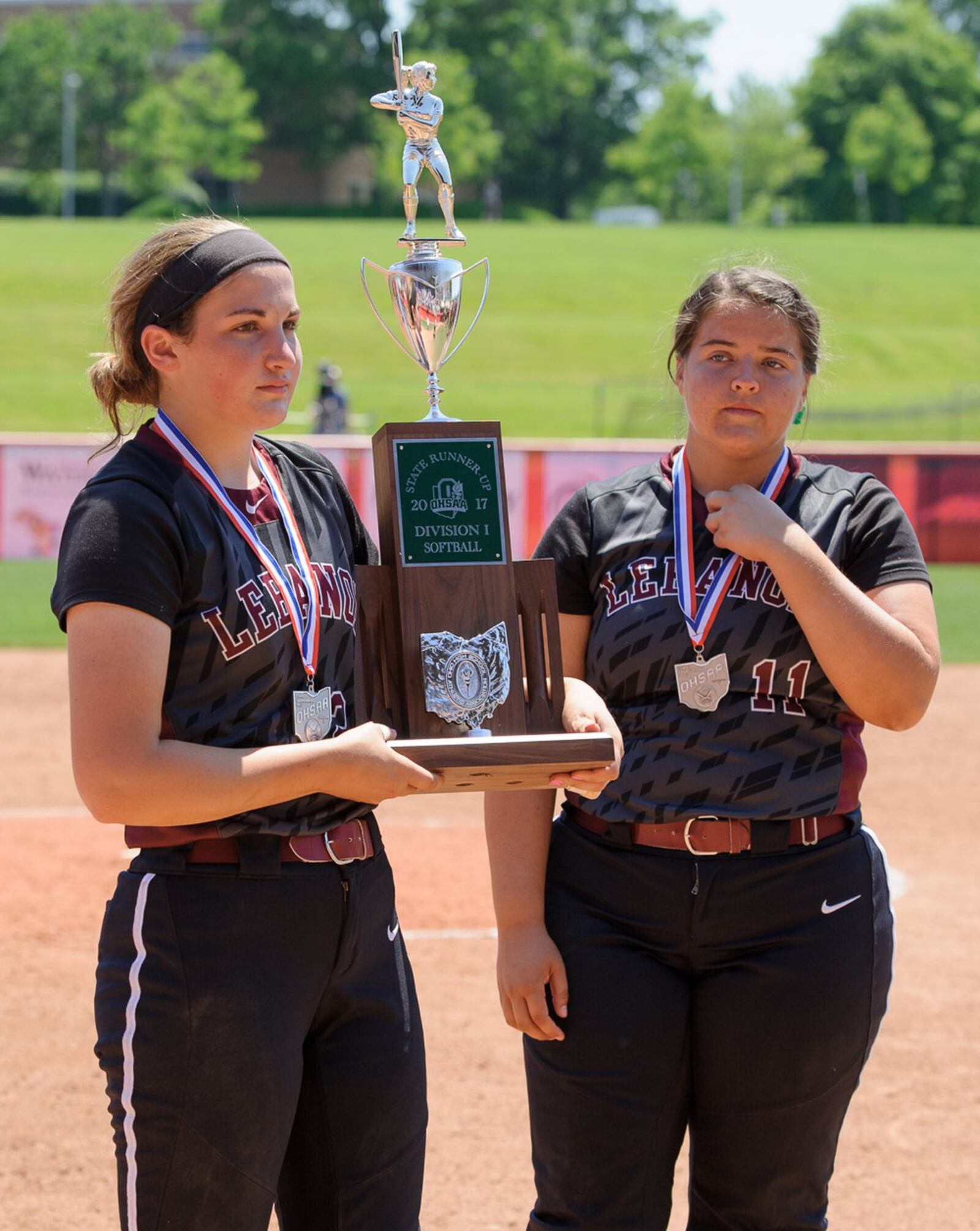 Lebanon’s Alex Gibson (right) holds the Division I state runner-up trophy as Alexis Strother watches following the state final against Elyria on Saturday at Firestone Stadium in Akron. CONTRIBUTED PHOTO BY BRYANT BILLING