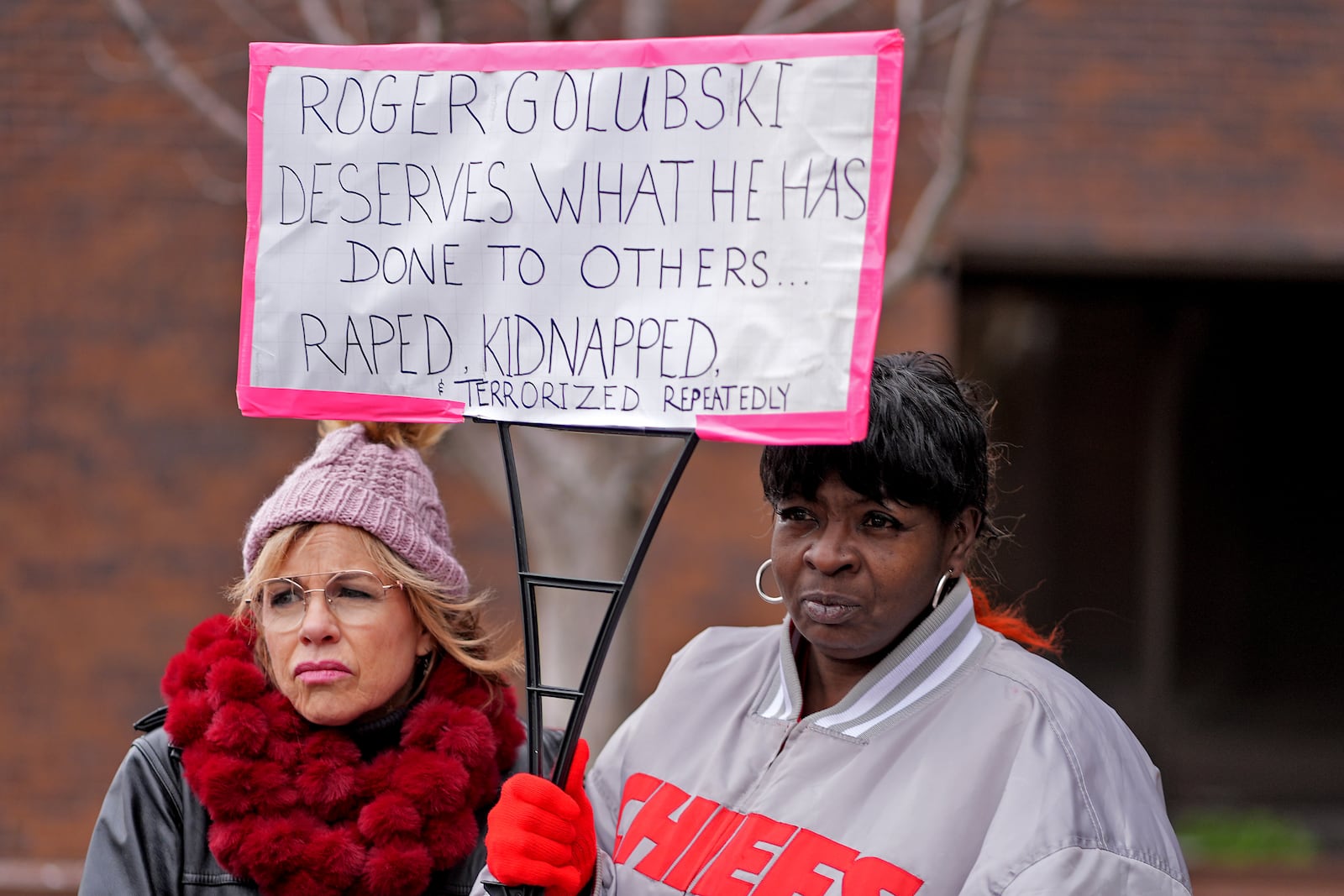 Lesa Mensa, left, and Anita Randle listen to a speaker at a rally outside the federal courthouse on was was to be the opening day for a trial for former police detective Roger Golubski, Monday, Dec. 2, 2024, in Topeka, Kan. (AP Photo/Charlie Riedel)