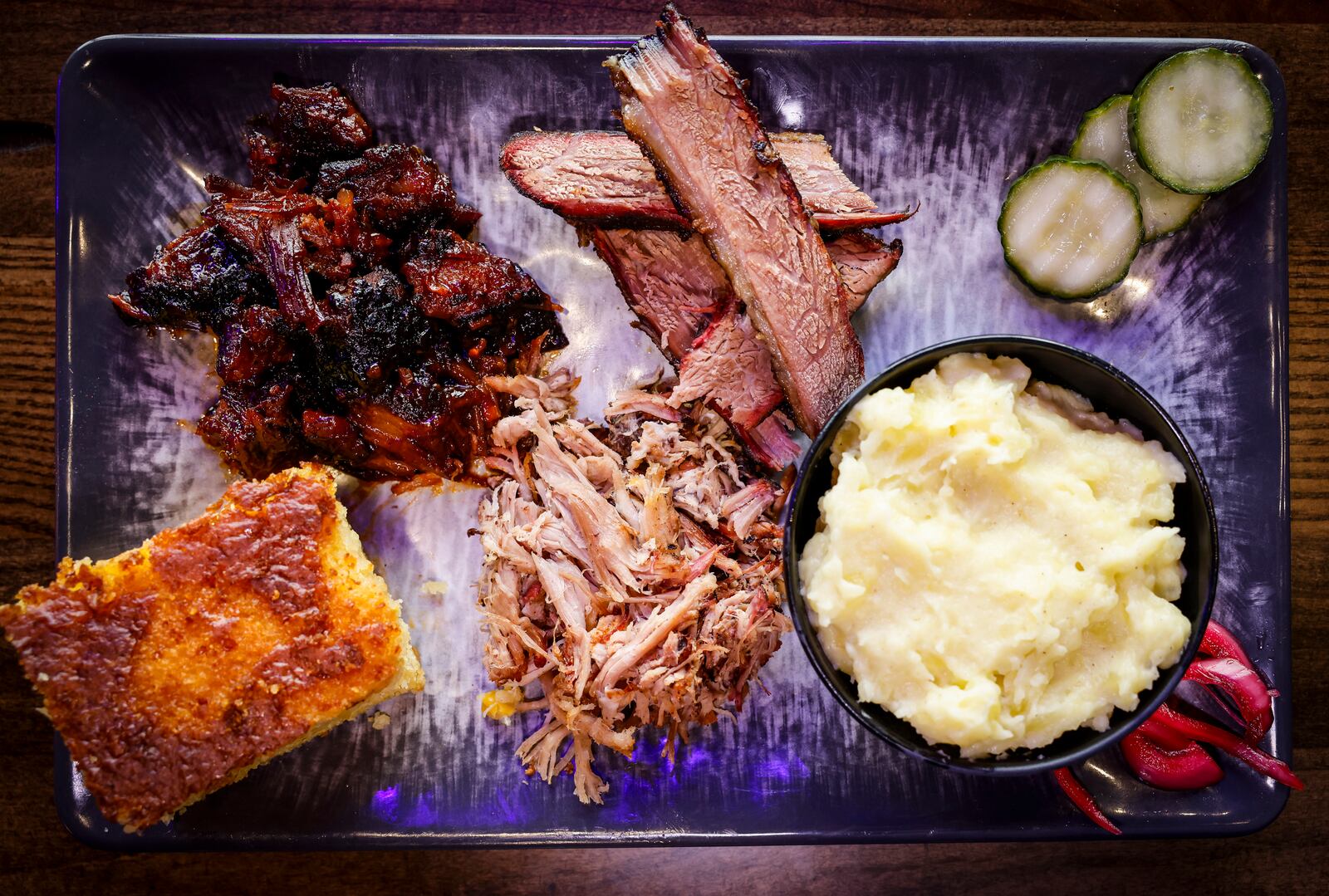 Cowboy Sally's Authentic Texas BBQ is now open at Liberty Center in Liberty Township. This plate shows a sampling of burnt ends, brisket, pulled pork, mashed potatoes and hot honey butter and pepper jack cornbread. NICK GRAHAM/STAFF