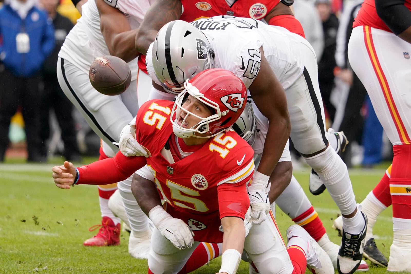 Kansas City Chiefs quarterback Patrick Mahomes (15) fumbles as he is hit by Las Vegas Raiders defensive end Malcolm Koonce (51) during the first half of an NFL football game Monday, Dec. 25, 2023, in Kansas City, Mo. (AP Photo/Ed Zurga)