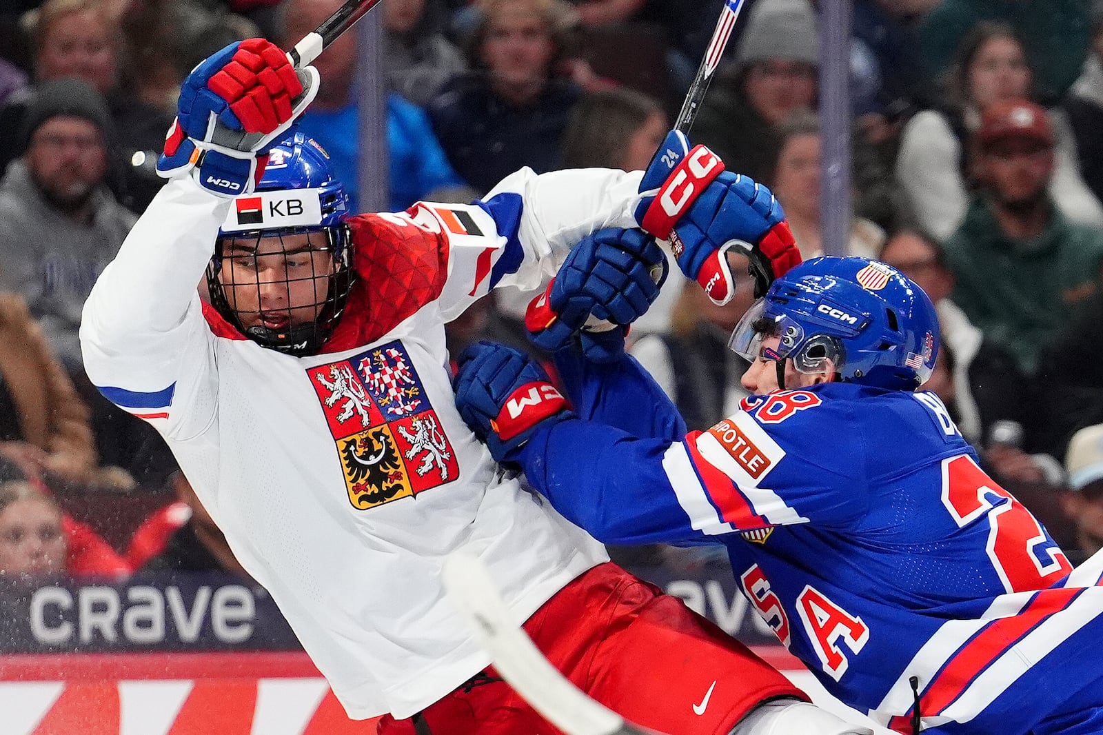 United States defenseman Zeev Buium (28) shoves Czechia forward Adam Novotny, left, during second-period World Junior hockey championship semifinal game action in Ottawa, Ontario, Saturday, Jan. 4, 2025. (Sean Kilpatrick/The Canadian Press via AP)