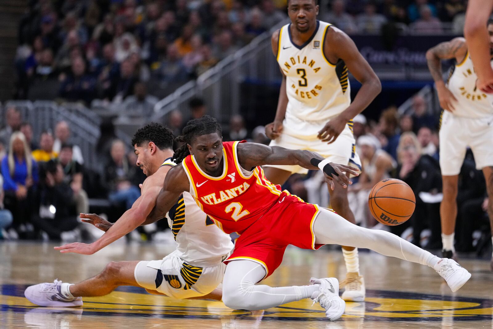 Atlanta Hawks guard Keaton Wallace (2) looses control of the ball as he falls with Indiana Pacers guard Ben Sheppard (26) during the second half of an NBA basketball game in Indianapolis, Saturday, Feb. 1, 2025. (AP Photo/Michael Conroy)