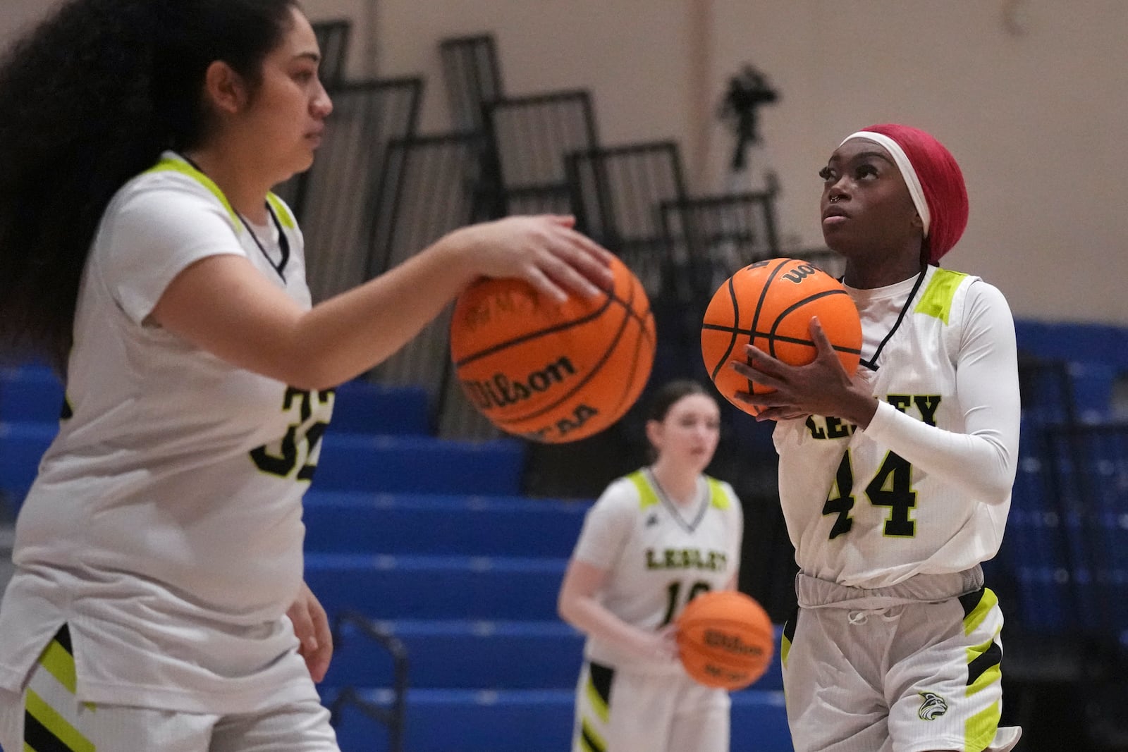 Lesley College basketball player Baileigh Sinaman-Daniel, right, lines up a shot while practicing prior to game Tuesday, Feb. 11, 2025, in Lexington, Mass. (AP Photo/Charles Krupa)