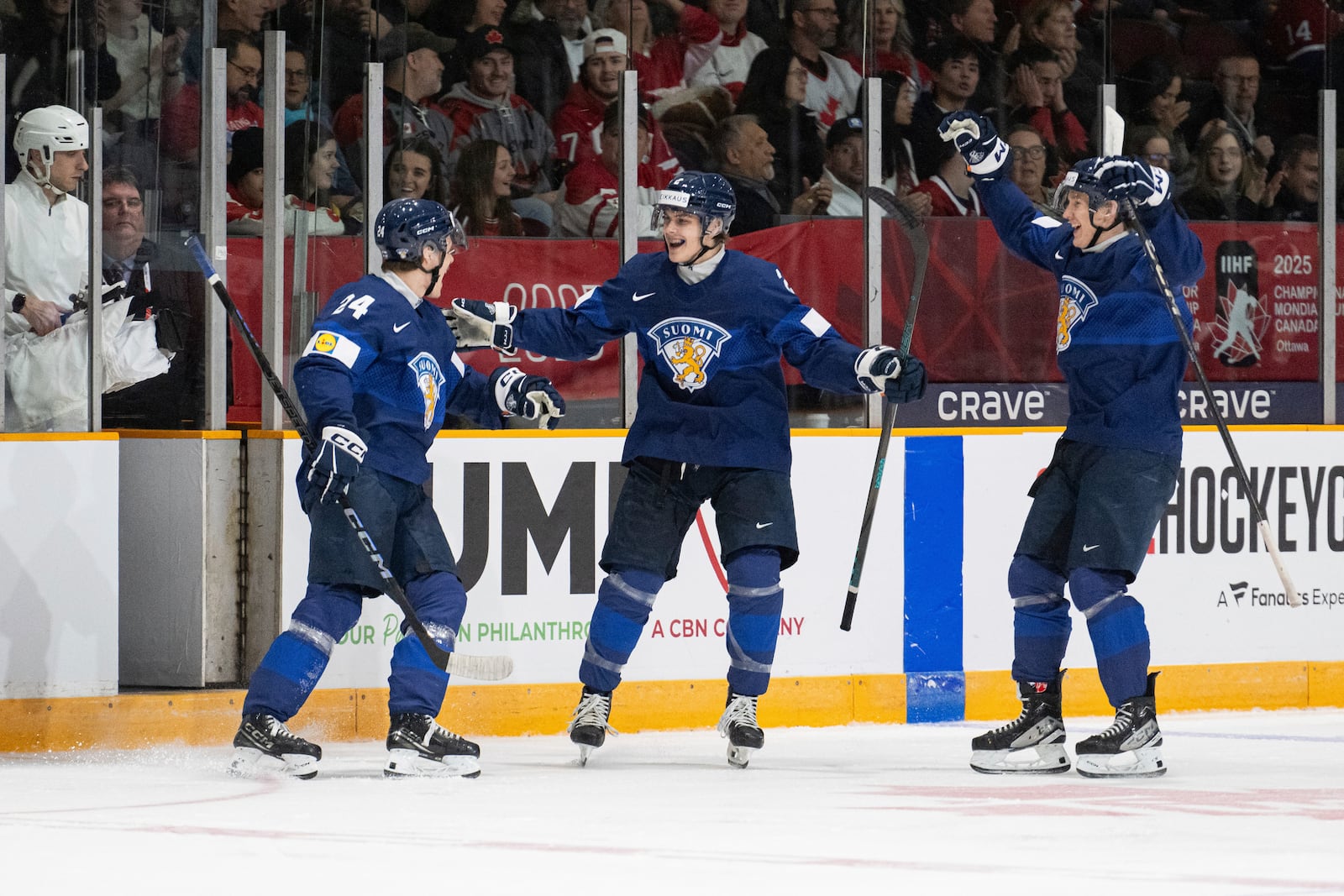 Finland forward Jesse Nurmi (24) celebrates his goal with teammates Mitja Jokinen (2) and Daniel Nieminen (7) during the first period of an IIHF World Junior Hockey Championship quarterfinal match against Slovakia in Ottawa, Ontario Thursday, Jan. 2, 2025. (Spencer Colby/The Canadian Press via AP)