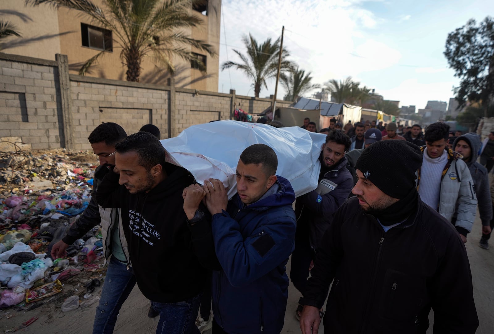 Mourners carry the body of a Palestinian killed in overnight Israeli airstrikes, during his funeral in the Khan Younis refugee camp, southern Gaza Strip, Saturday, Jan. 4, 2025. (AP Photo/Abdel Kareem Hana)