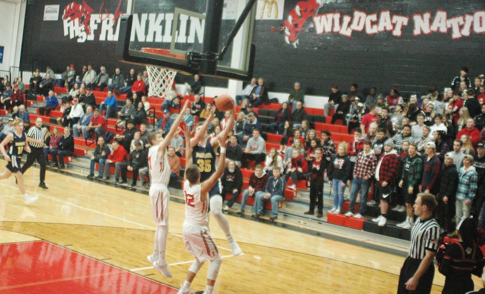 Monroe’s Caimanne Turner (35) goes up for shot as Franklin’s Will Emrick (11) and Braden Woods (12) defend Tuesday night at Darrell Hedric Gym in Franklin. The host Wildcats won 67-42. RICK CASSANO/STAFF