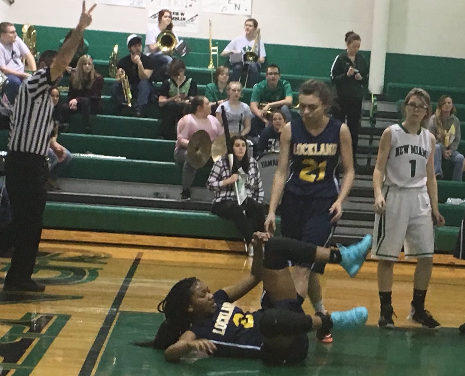 Lockland’s Erin Goins (2) is about to go to the foul line after getting fouled in the lane during Wednesday night’s game at New Miami. Teammate Sidney Vance (21) offers to help her up as the Vikings’ Brooklyn Adkins (1) trails the play. RICK CASSANO/STAFF