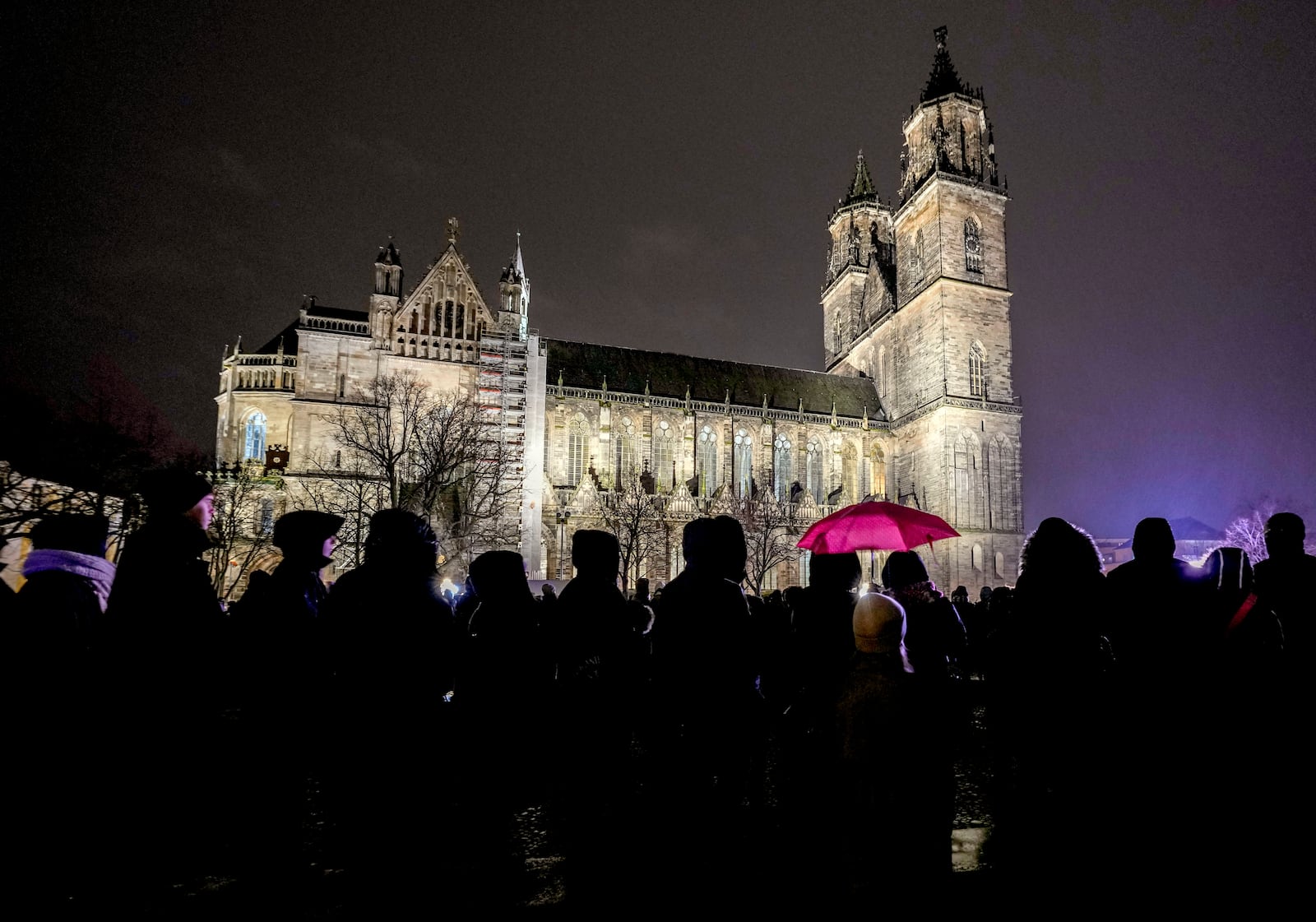 People attend a memorial service outside the cathedral close to the Christmas market, where a car drove into a crowd on Friday evening, in Magdeburg, Germany, Saturday, Dec. 21, 2024. (AP Photo/Michael Probst)