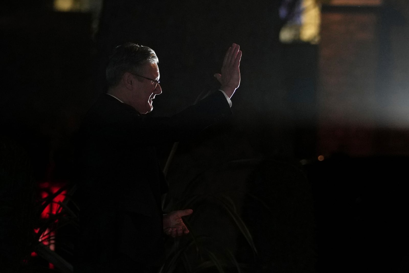 Britain's Prime Minister Keir Starmer, lit by a photographers flash, waves goodbye to Ukraine's President Volodymyr Zelenskyy following a meeting inside 10 Downing Street in London Saturday, March 1, 2025. (AP Photo/Kin Cheung)