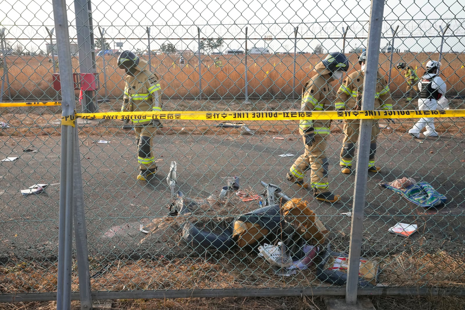 Rescue team members work near the wreckage of a passenger plane outside of Muan International Airport in Muan, South Korea, Sunday, Dec. 29, 2024. (AP Photo/Ahn Young-joon)