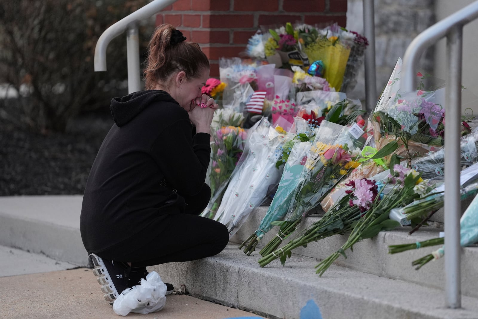 A person gets emotional after leaving flowers in front of the West York Police Department after a police officer was killed responding to a shooting at UPMC Memorial Hospital in York, Pa. on Saturday, Feb. 22, 2025. (AP Photo/Matt Rourke)