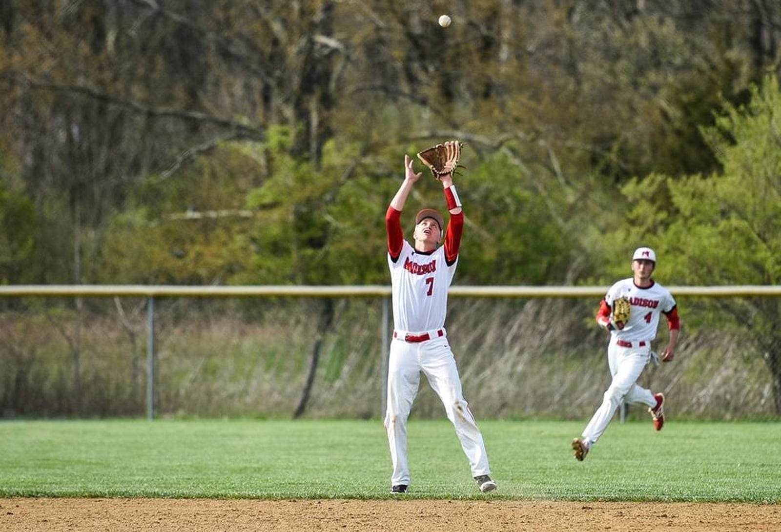 Madison’s Turner Campbell (7) is about to catch a pop-up as right fielder Jake Edwards (4) backs him up during Thursday’s game against Carlisle at Madison. NICK GRAHAM/STAFF