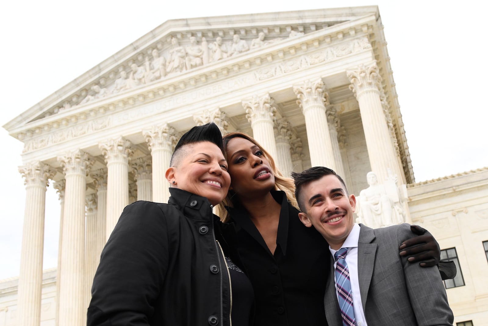 FILE - Sara Ramirez, from left, Laverne Cox and Chase Strangio, an attorney with the American Civil Liberties Union, pose for a photo outside the Supreme Court in Washington, Oct. 8, 2019. (AP Photo/Susan Walsh, File)