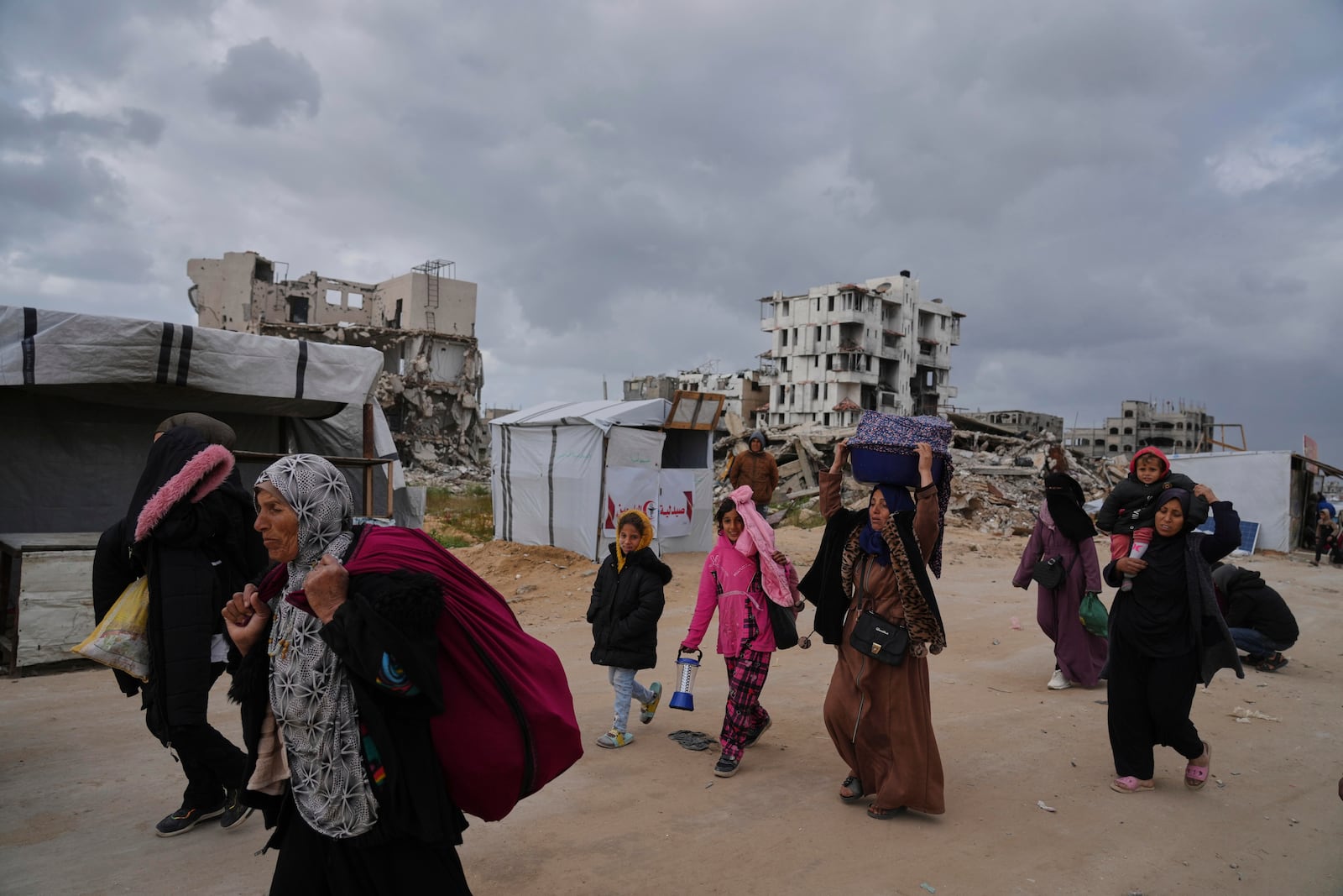 Displaced Palestinians, carrying their belongings, move away from the areas where the Israeli army is operating after Israel's renewed offensive in the Gaza Strip, on the outskirts of Beit Lahia, Thursday, March 20, 2025. (AP Photo/Jehad Alshrafi)