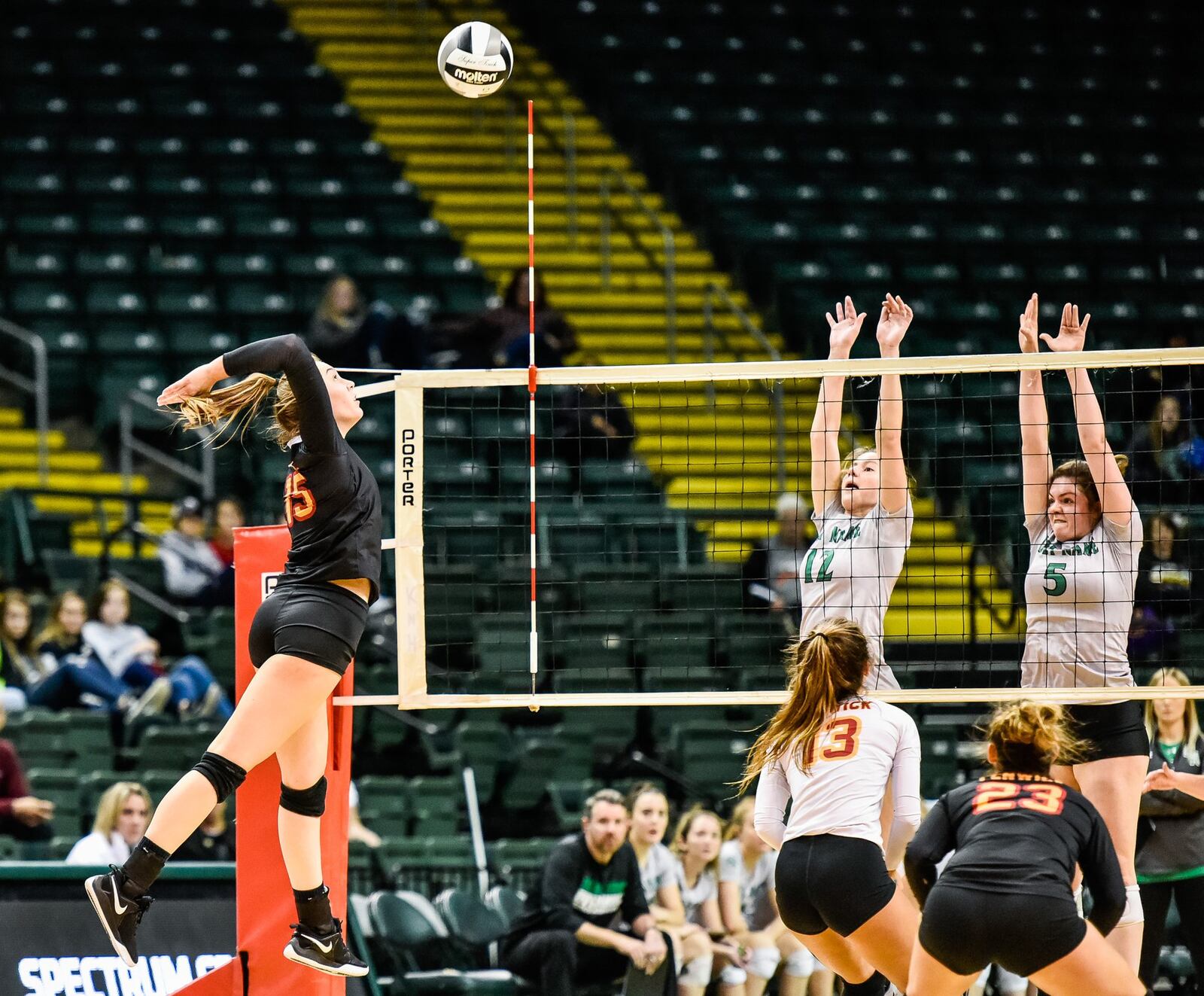 Fenwick’s Julia Gardon winds up for a shot at Parma Heights Holy Name’s Ava Nice (5) and Kayla Jarosz (12) during Friday’s Division II state volleyball semifinal at Wright State University’s Nutter Cener. NICK GRAHAM/STAFF