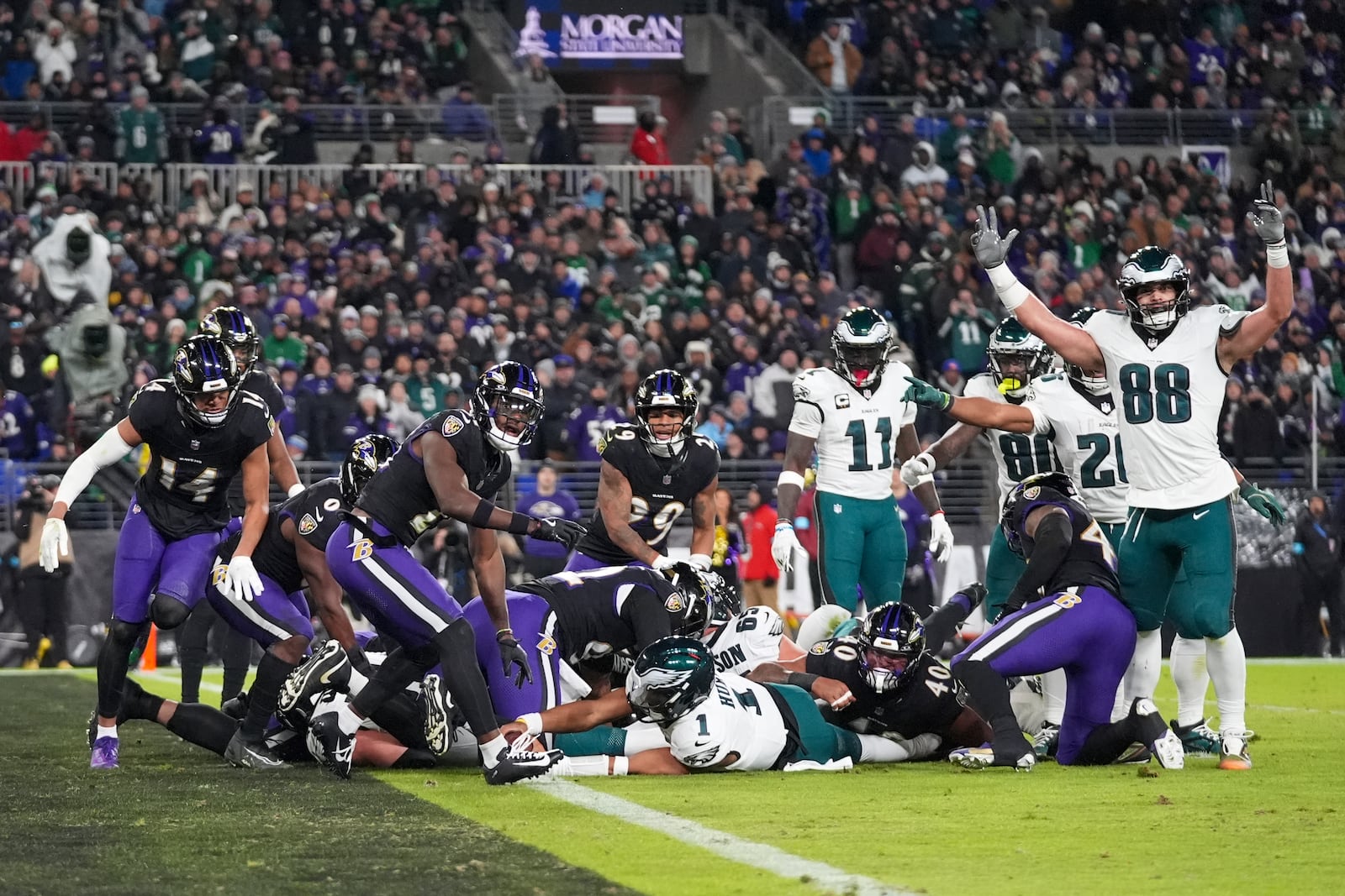 Philadelphia Eagles quarterback Jalen Hurts, bottom center, recovers his fumble to score a touchdown on a keeper against the Baltimore Ravens during the first half of an NFL football game, Sunday, Dec. 1, 2024, in Baltimore. (AP Photo/Stephanie Scarbrough)