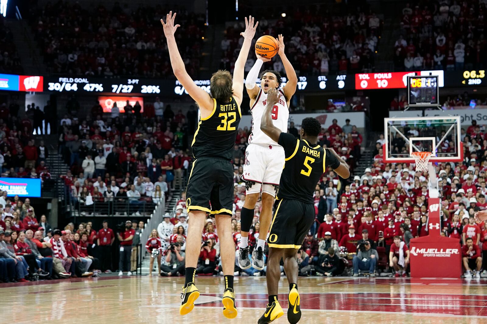 Wisconsin guard John Tonje (9) attempts a 3-point basket over Oregon center Nate Bittle (32) and guard TJ Bamba (5) during overtime of an NCAA college basketball game Saturday, Feb. 22, 2025, in Madison, Wis. (AP Photo/Kayla Wolf)