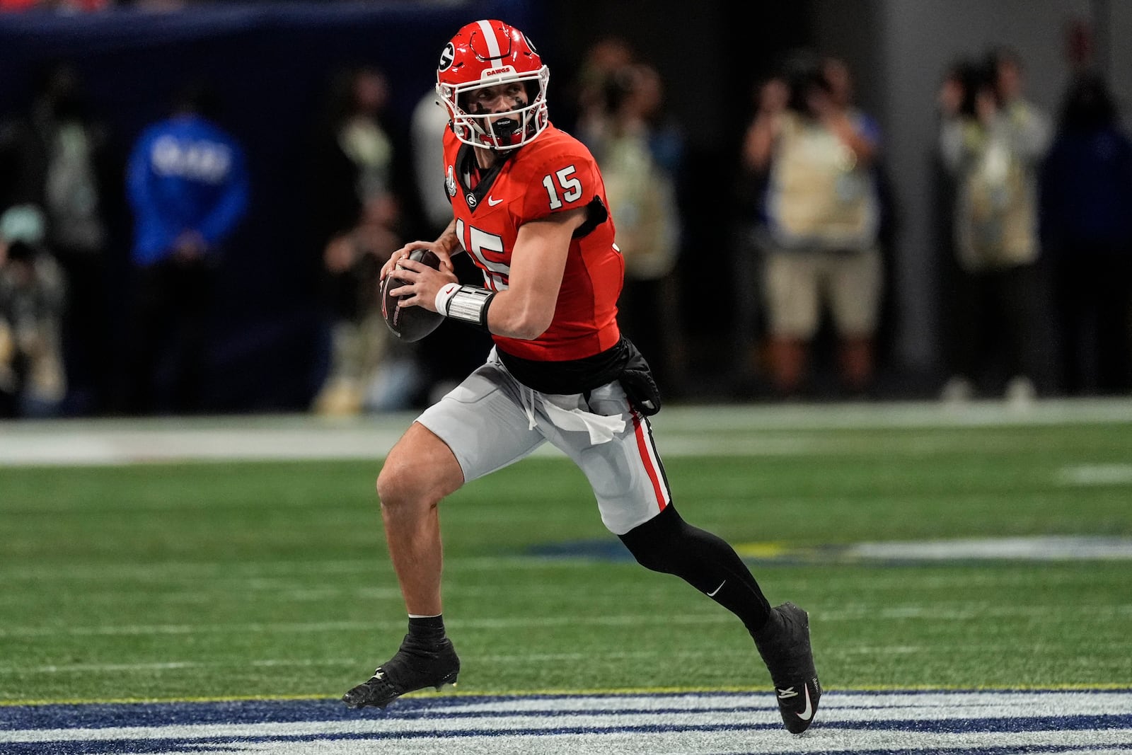 Georgia quarterback Carson Beck (15) runs out of the pocket against Texas during the first half of the Southeastern Conference championship NCAA college football game, Saturday, Dec. 7, 2024, in Atlanta. (AP Photo/John Bazemore)