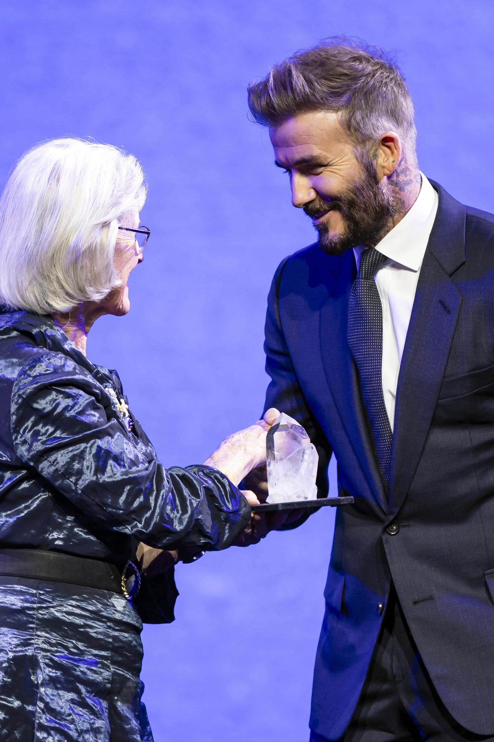 David Beckham, right, receives a Crystal Award from Hilde Schwab, Chairperson and Co-Founder, Schwab Foundation for Social Entrepreneurship during the ceremony for the Crystal Awards at the 55th annual meeting of the World Economic Forum, WEF, in Davos, Switzerland, on Monday, Jan. 20, 2025. (Michael Buholzer/Keystone via AP)