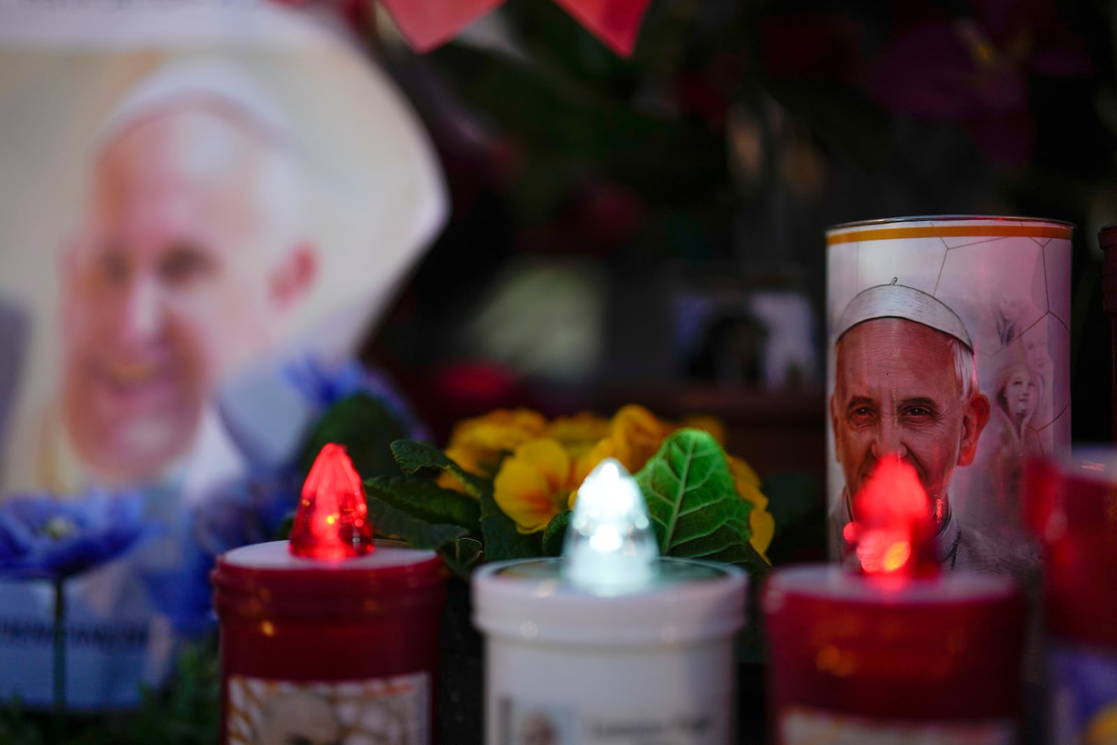 Candles are seen near pictures of Pope Francis outside the Agostino Gemelli Polyclinic in Rome, Sunday, Feb. 23, 2025, where the Pontiff is hospitalized since Feb. 14. (AP Photo/Gregorio Borgia)