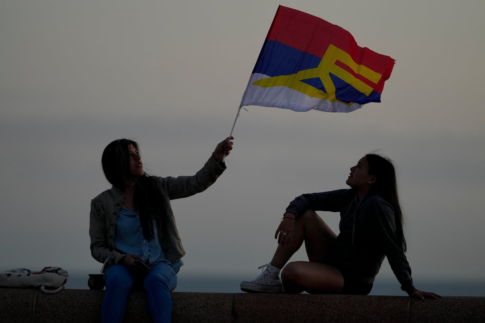 A woman holds a Frente Amplio party flag during general elections in Montevideo, Uruguay, Sunday, Oct. 27, 2024. (AP Photo/Natacha Pisarenko)