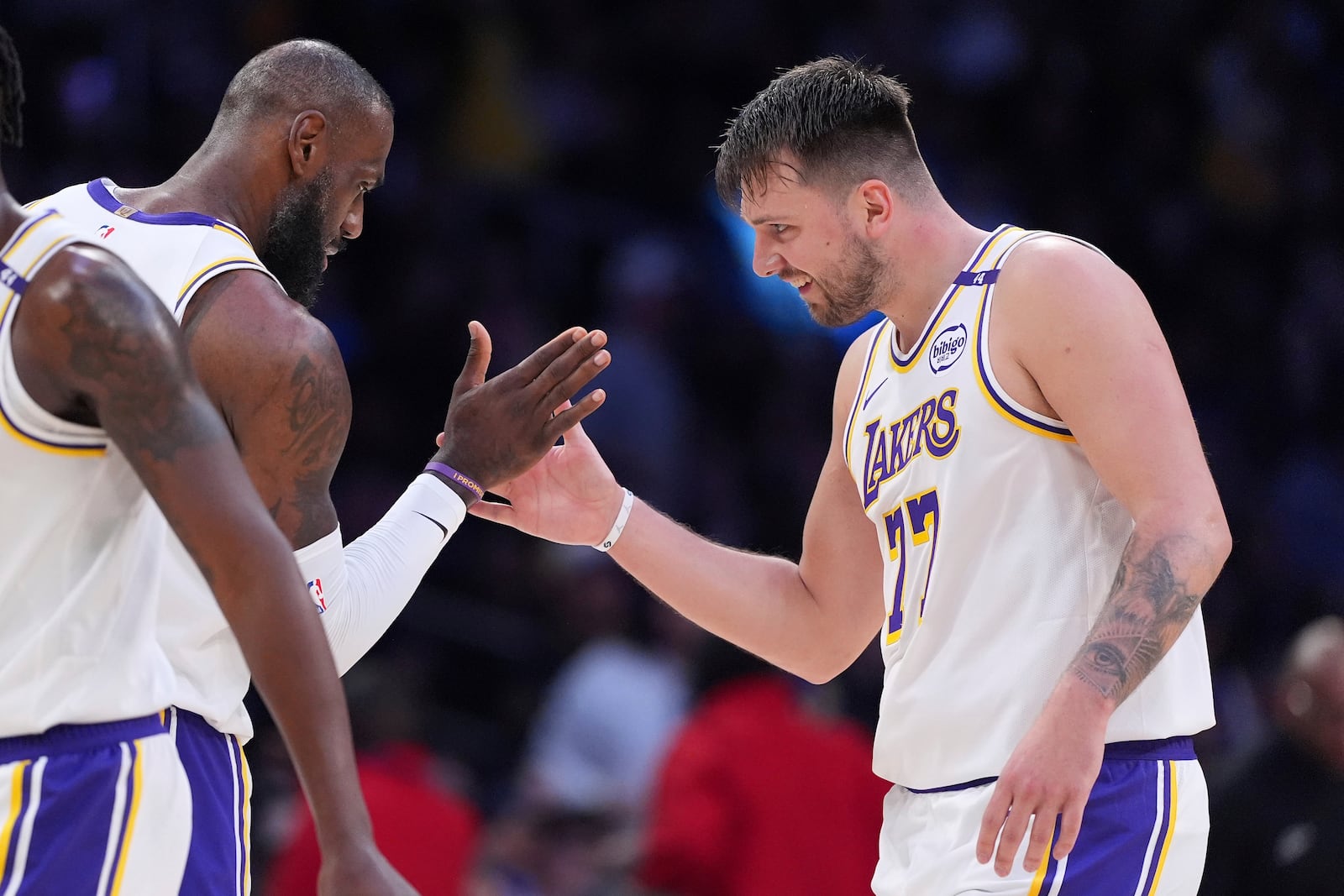 Los Angeles Lakers guard Luka Doncic, right, is congratulated by forward LeBron James after scoring during the first half of an NBA basketball game against the Los Angeles Clippers, Sunday, March 2, 2025, in Los Angeles. (AP Photo/Mark J. Terrill)