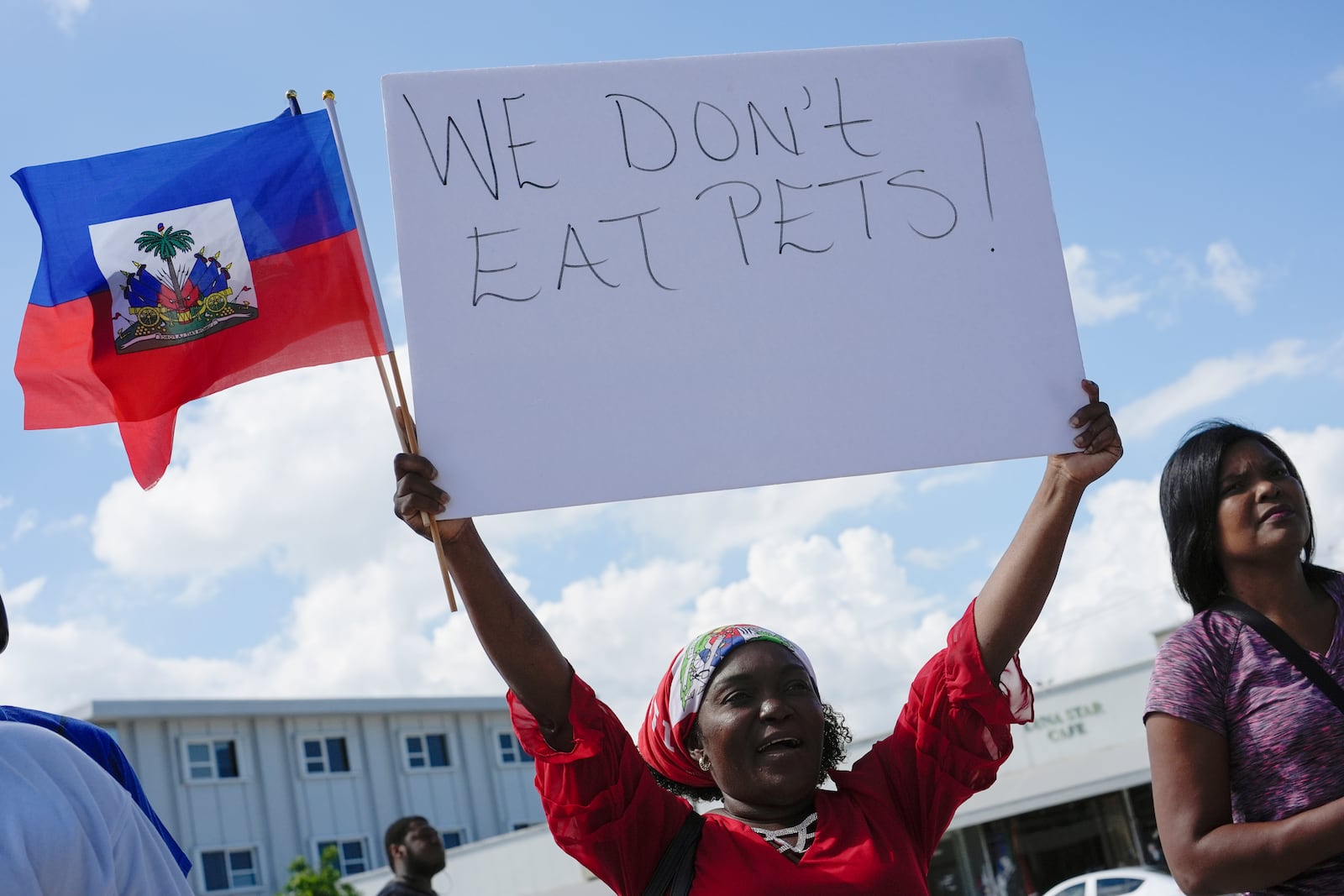 FILE - Wilda Brooks of West Palm Beach, Fla., holds up a sign reading "We don't eat pets," during a rally by members of South Florida's Haitian-American community to condemn hate speech and misinformation about Haitian immigrants, Sunday, Sept. 22, 2024, in North Miami, Fla. (AP Photo/Rebecca Blackwell, File)