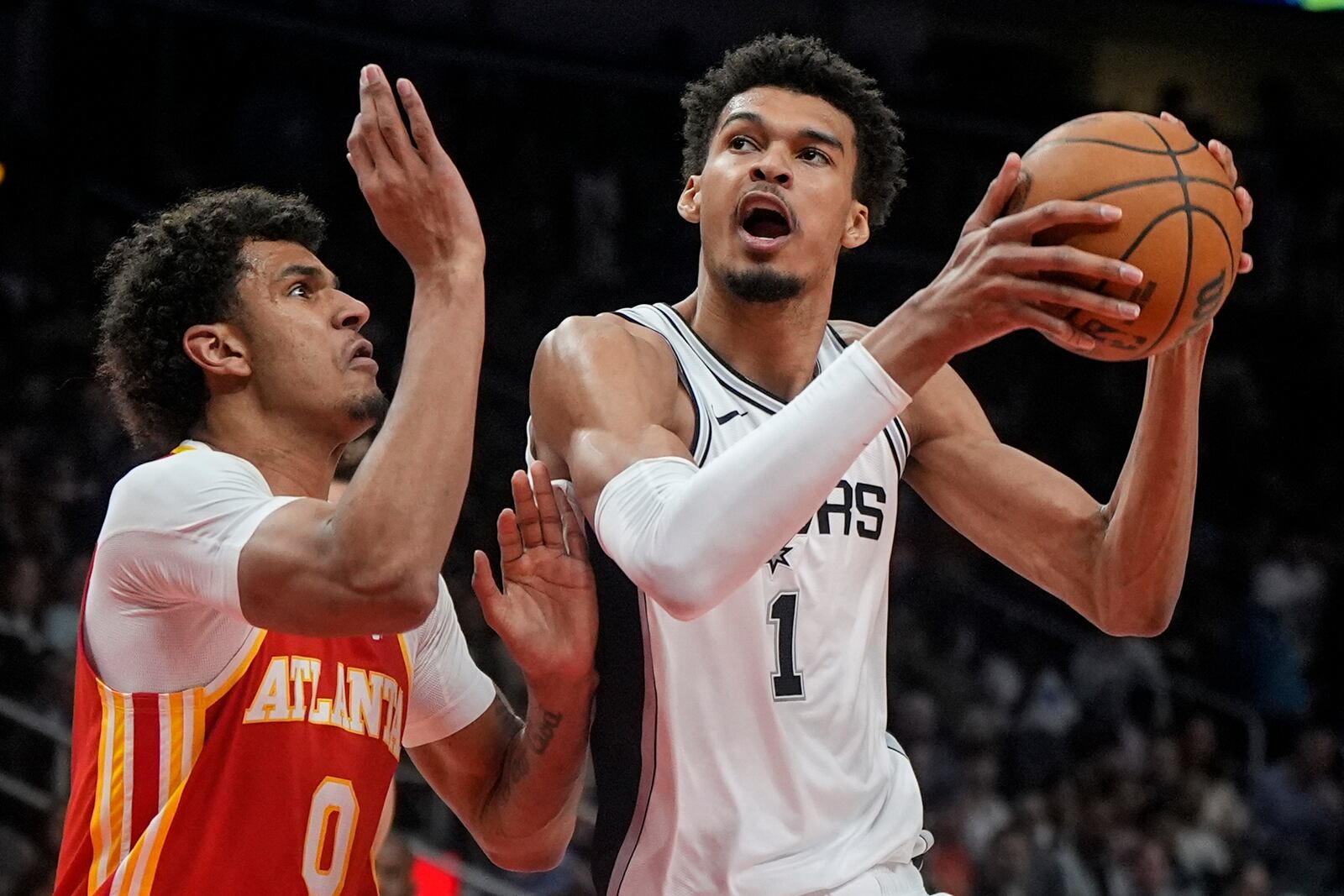 San Antonio Spurs center Victor Wembanyama (1) shoots against Atlanta Hawks Dominick Barlow during the first half of an NBA basketball game, Wednesday, Feb. 5, 2025, in Atlanta. (AP Photo/Mike Stewart)