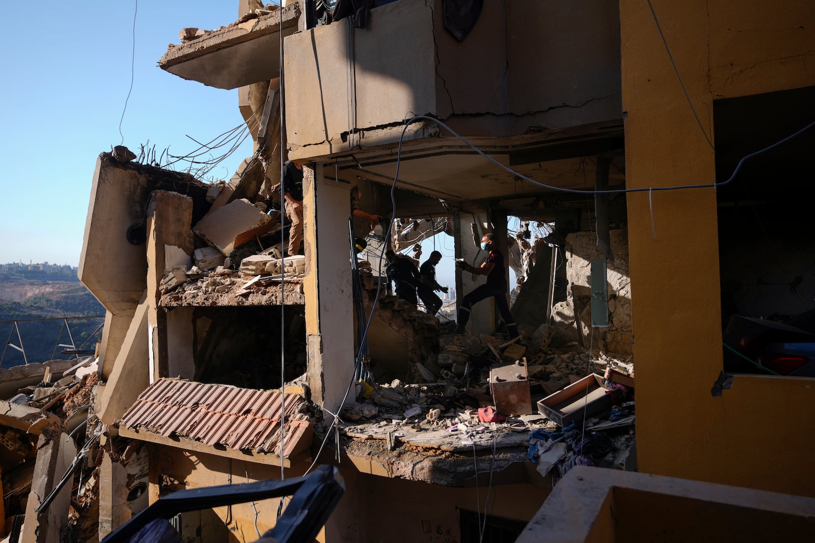 Rescue workers search for victims in the rubble of a destroyed building hit in an Israeli airstrike on Tuesday night, in Barja, Lebanon, Wednesday, Nov. 6, 2024. (AP Photo/Hassan Ammar)