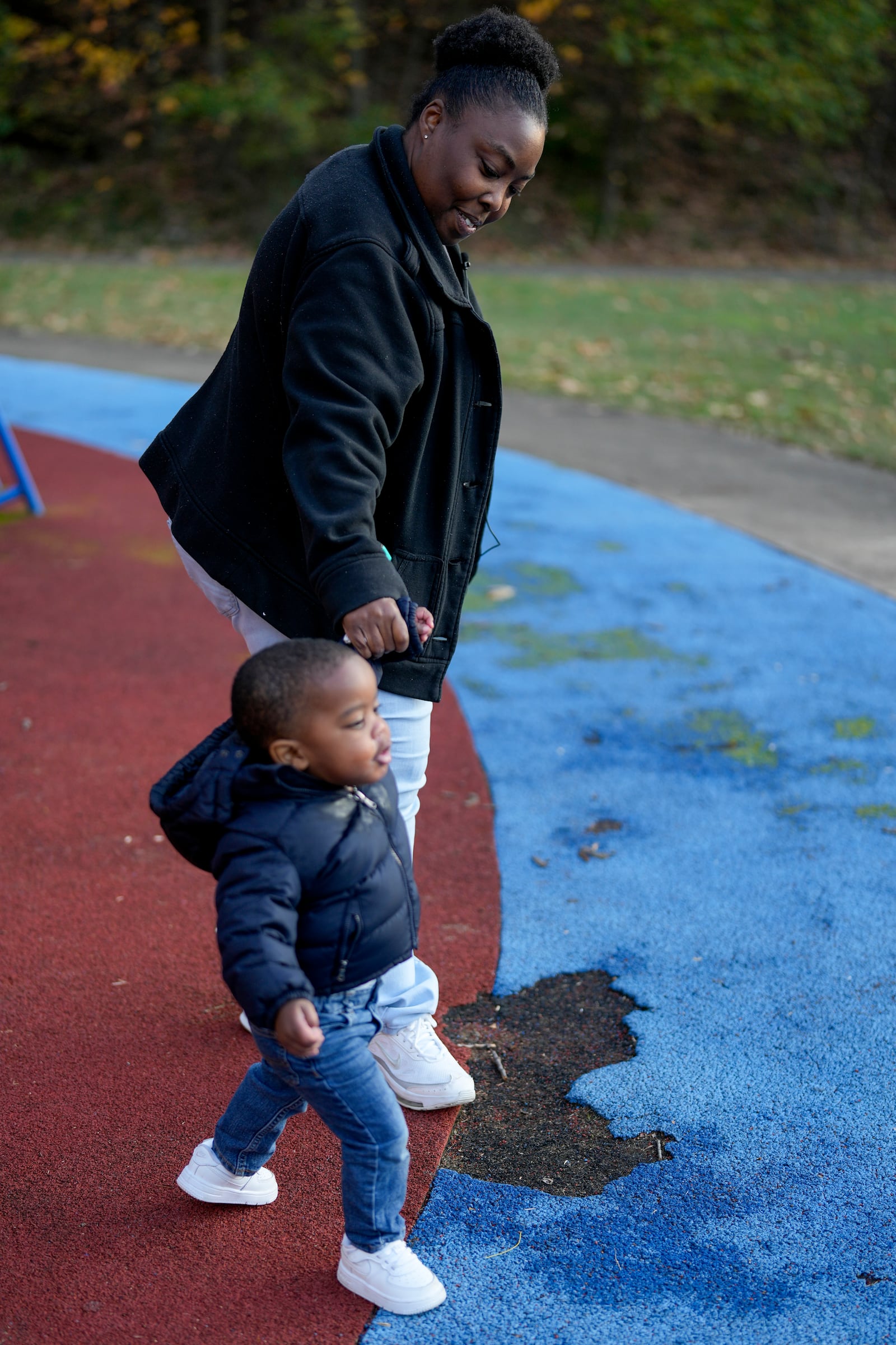 Anika Chillis, left, spends time with her son, Makhi, 2, at a playground Monday, Dec. 2, 2024, in Memphis, Tenn. (AP Photo/George Walker IV)