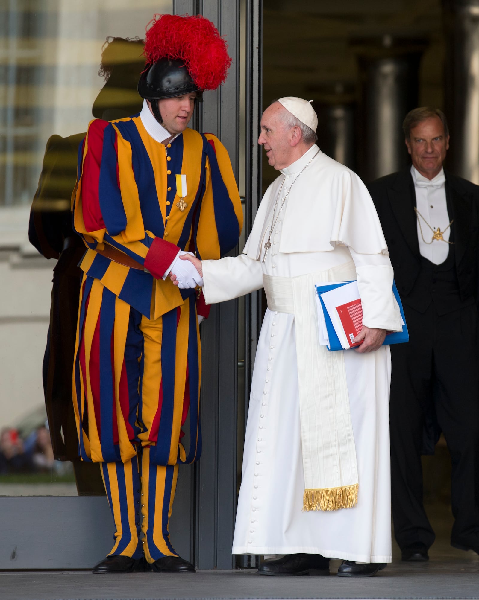 FILE - In this Oct. 16, 2015 file photo, Pope Francis shakes hands with a Vatican Swiss guard as he leaves after a morning session of the Synod of bishops, at the Vatican. (AP Photo/Alessandra Tarantino, file)