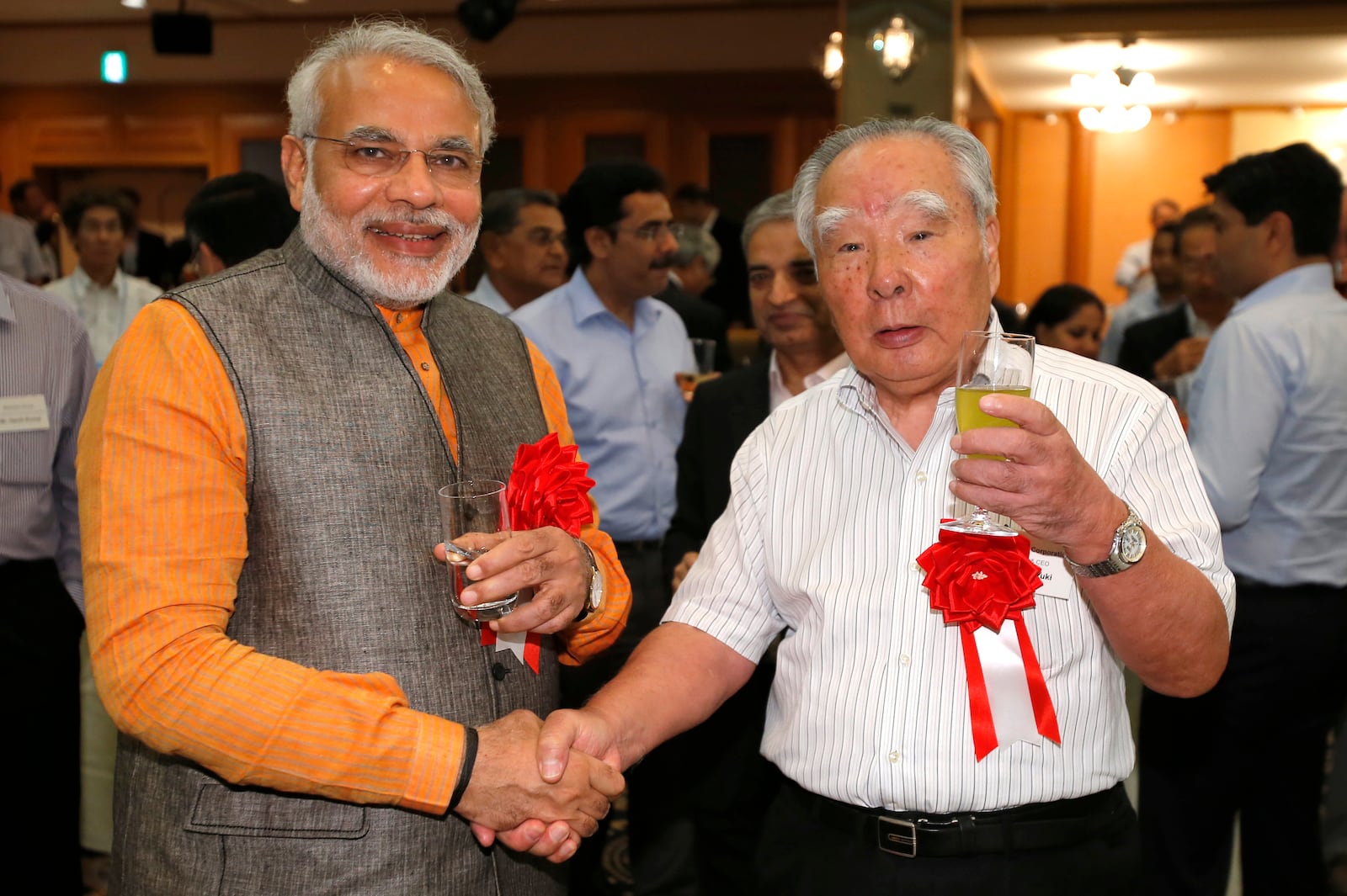 FILE - Then India's Gujarat State Chief Minister Nerendra Modi, left, poses with Suzuki Motor Corp. Chairman and Chief Executive Osamu Suzuki for a photo during a reception of the "Invest Gujarat" seminar in Hamamatsu, southwest of Tokyo, July 25, 2012. (AP Photo/Shizuo Kambayashi, File)