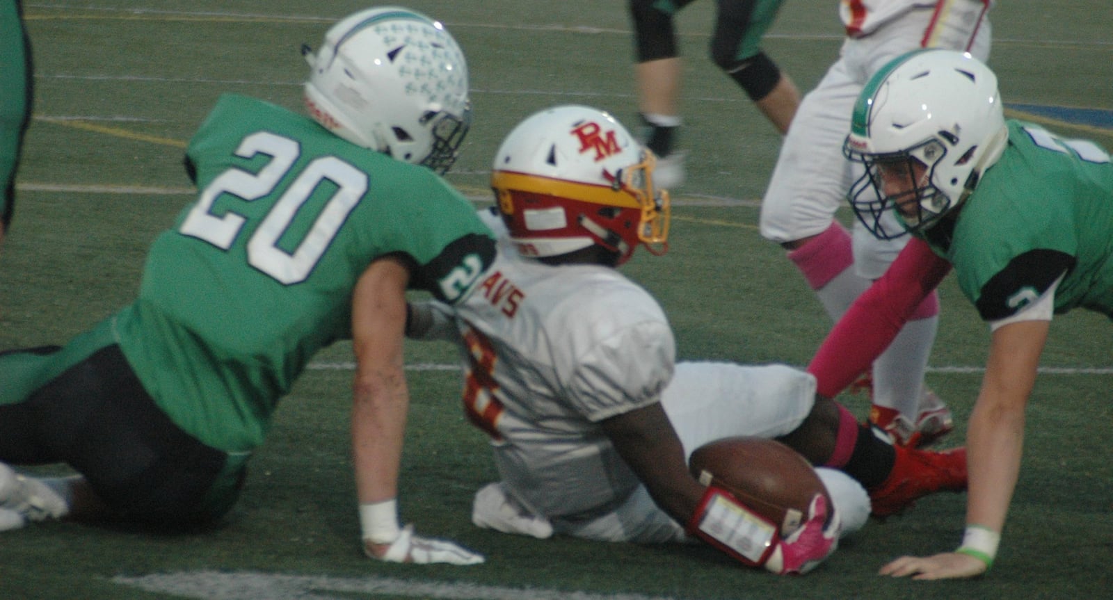 Badin’s Alex DeLong (20) and Bobby Young (2) surround Purcell Marian’s Torrence Johnson (8) after a tackle Saturday night at Monroe. Badin recorded a 24-7 triumph. RICK CASSANO/STAFF