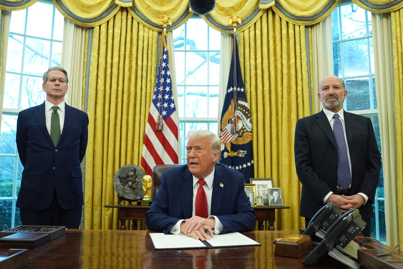 FILE - President Donald Trump speaks as Treasury Secretary Scott Bessent, left, and Commerce Secretary nominee Howard Lutnick, right, listen as Trump prepares to sign an executive order in the Oval Office of the White House, Monday, Feb. 3, 2025, in Washington. (AP Photo/Evan Vucci, File)