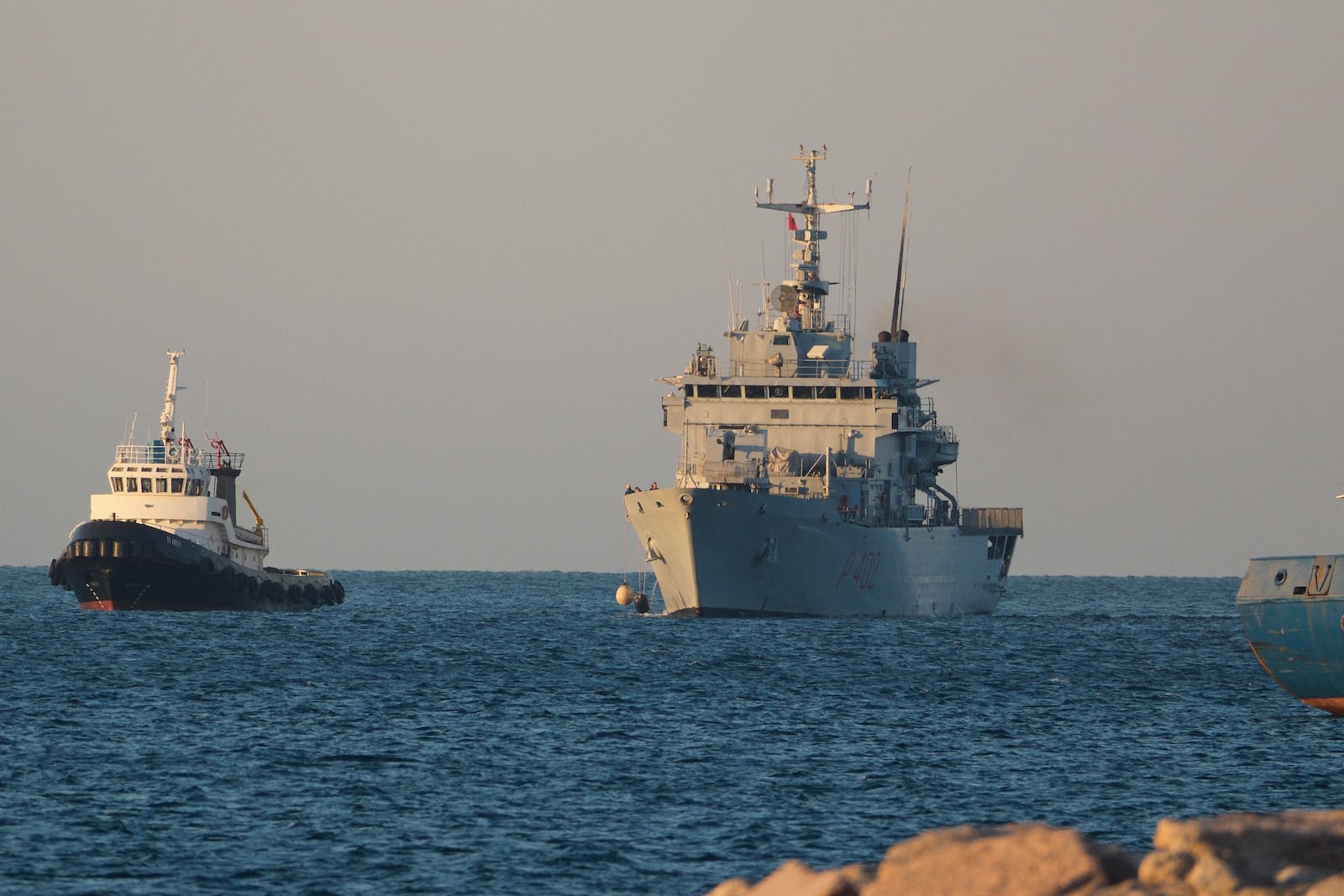 The Italian navy ship Libra, right, arrives at the port of Shengjin northwestern Albania Wednesday, Oct. 16, 2024, carrying the first group of migrants who were intercepted in international waters. (AP Photo/Vlasov Sulaj)