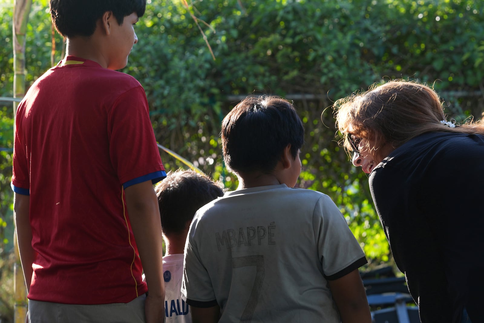 Immigration advocate Nora Sandigo talks to three brothers after their parents signed guardianship papers, Sunday, Feb. 2, 2025, in Homestead, Fla. (AP Photo/Marta Lavandier)