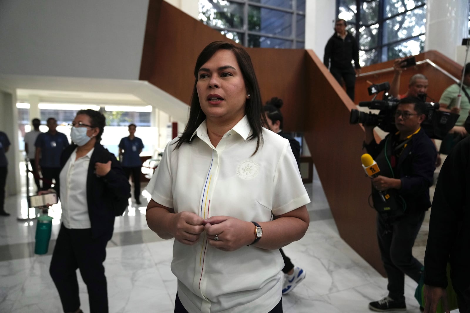 Philippine Vice President Sara Duterte, center, walks while a hearing she is attending is suspended at the House of Representative in Quezon City, Philippines Monday, Nov. 25, 2024. (AP Photo/Aaron Favila)