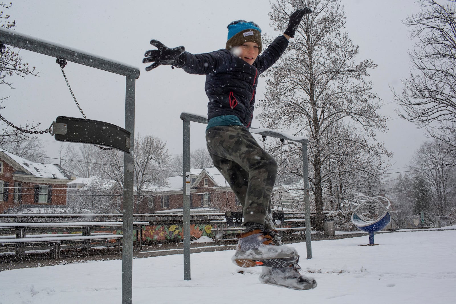 Will Bowles jumps off a swing set during a winter snowstorm in Charlottesville, Va., Tuesday, Feb. 11, 2025. (Cal Cary/The Daily Progress via AP)