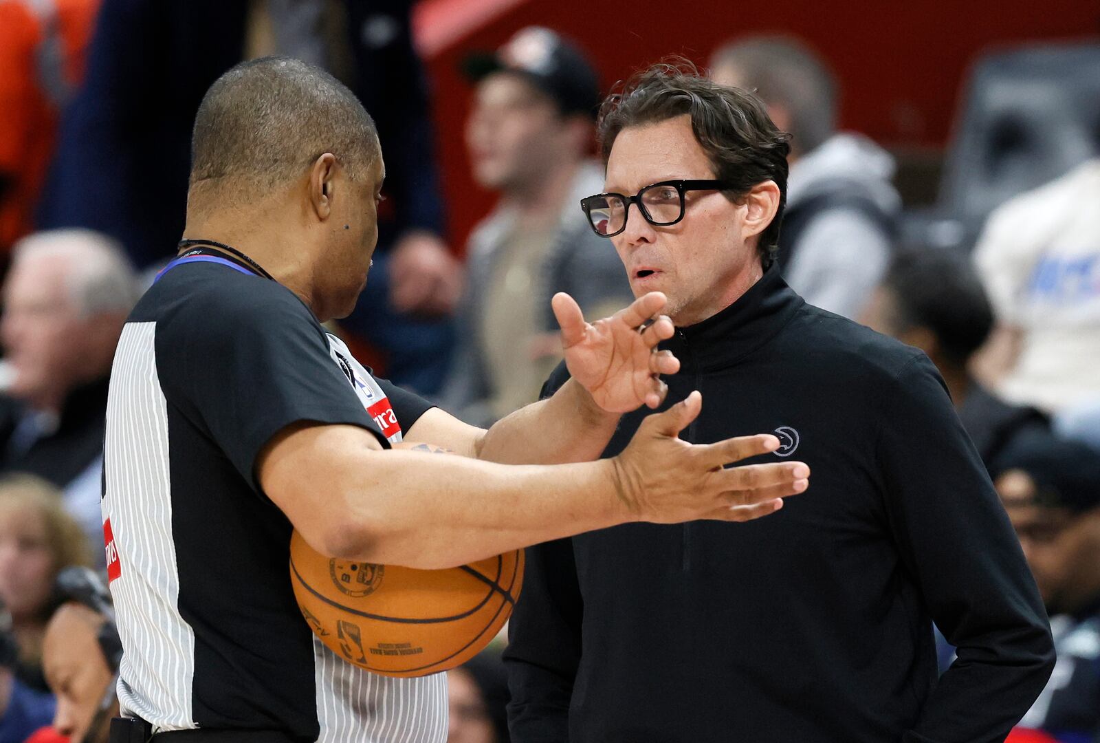 Atlanta Hawks head coach Quin Snyder, right, receives an explanation from referee Tony Brothers, left, during the first half of an NBA basketball game against the Detroit Pistons, Monday, Feb. 3, 2025, in Detroit. (AP Photo/Duane Burleson)