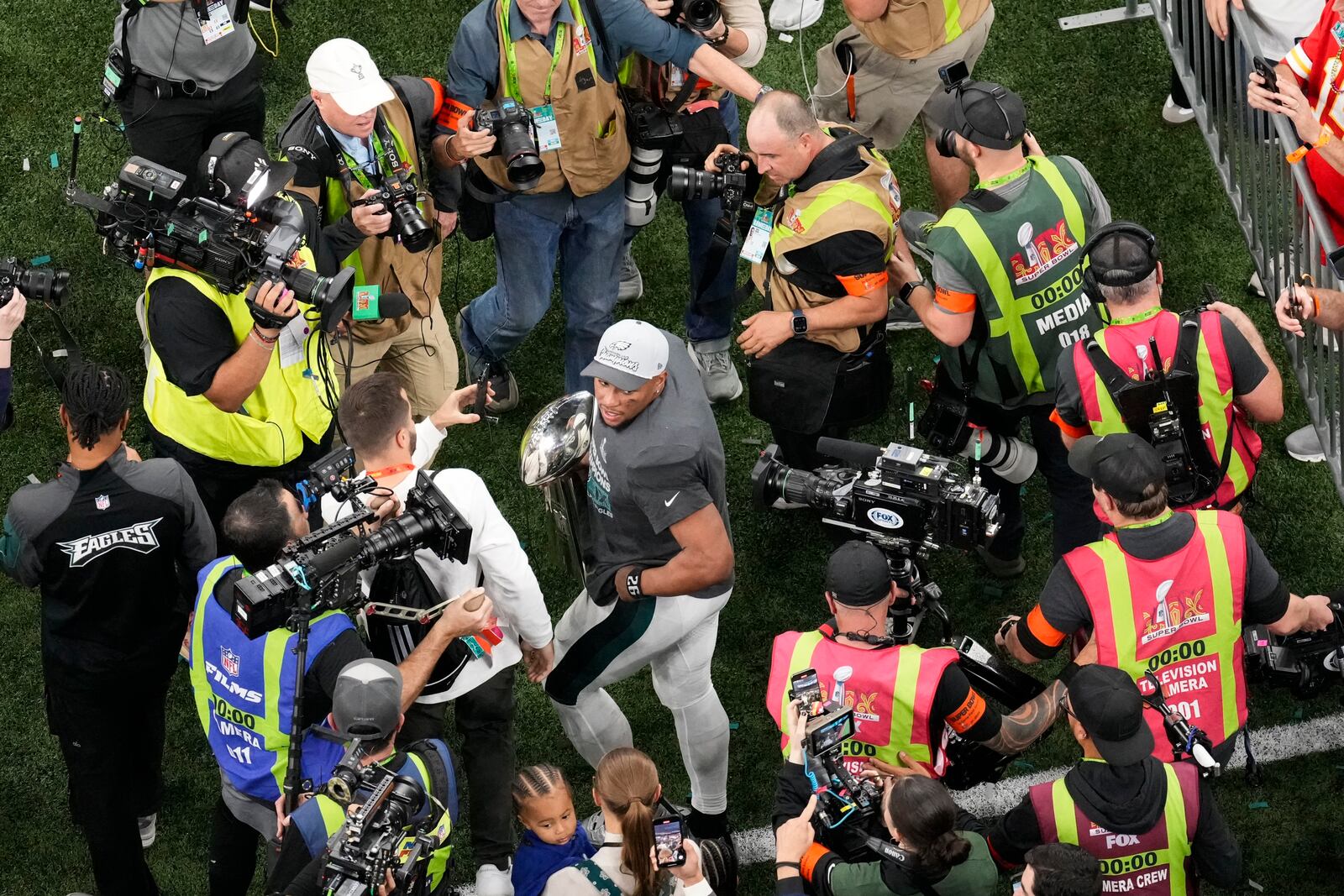 Philadelphia Eagles running back Saquon Barkley carries the Vince Lombardi Trophy after the Eagles won the NFL Super Bowl 59 football game against the Kansas City Chiefs, Sunday, Feb. 9, 2025, in New Orleans. (AP Photo/David J. Phillip)