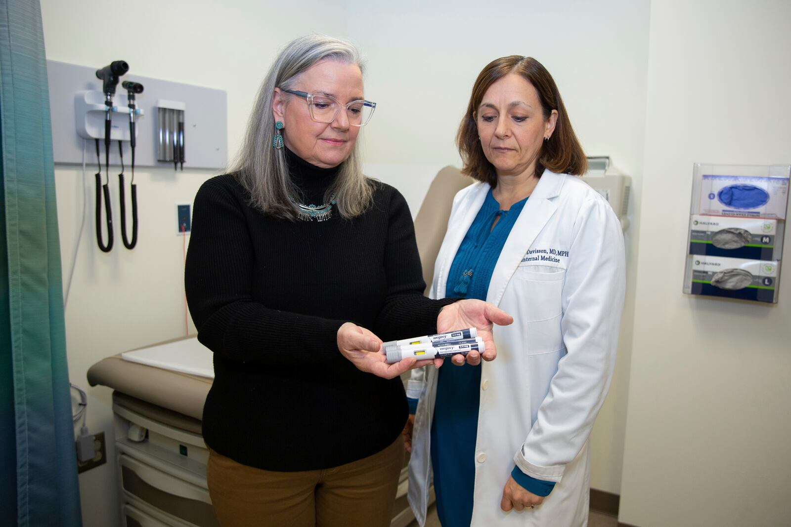 Patient Lory Osborn (left) holds Wegovy pens used in her treatment with Dr. Laura Davisson, director of the Medical Weight Management at West Virginia University in Morgantown, W.Va., Monday, Dec. 2, 2024. (AP Photo/Kathleen Batten)