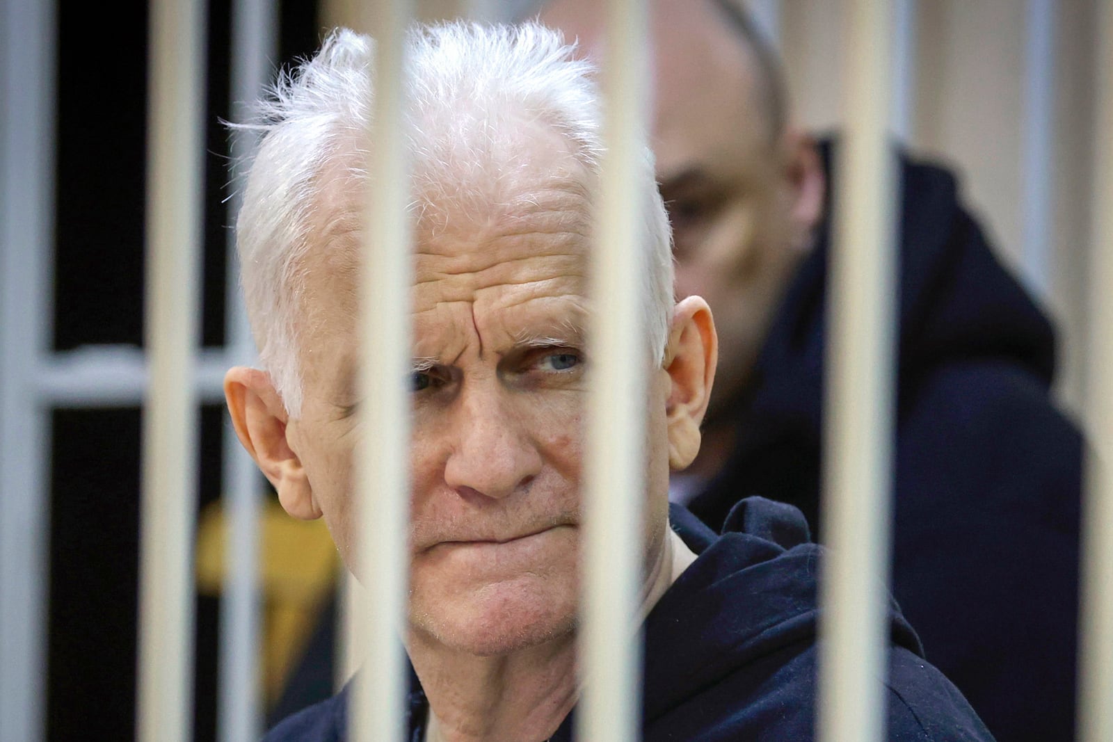 FILE – Belarusian Nobel Peace Prize winner Ales Bialiatski, head of the Viasna human rights group, sits in a defendants' cage in a court in Minsk, Belarus, on Jan. 5, 2023. (Vitaly Pivovarchyk/BelTA Pool Photo via AP, File)