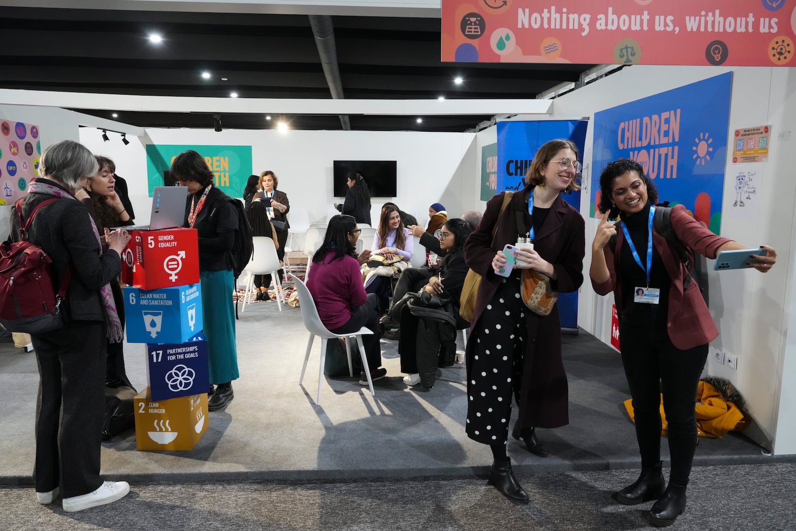 Attendees pose at the Children and Youth Pavilion at the COP29 U.N. Climate Summit, Monday, Nov. 18, 2024, in Baku, Azerbaijan. (AP Photo/Sergei Grits)