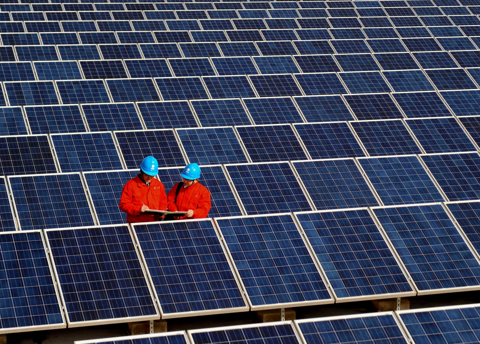 FILE - Workers check solar panels at a solar power station on a factory roof in Changxing, eastern China's Zhejiang province on Feb. 7, 2012. (AP Photo/File)