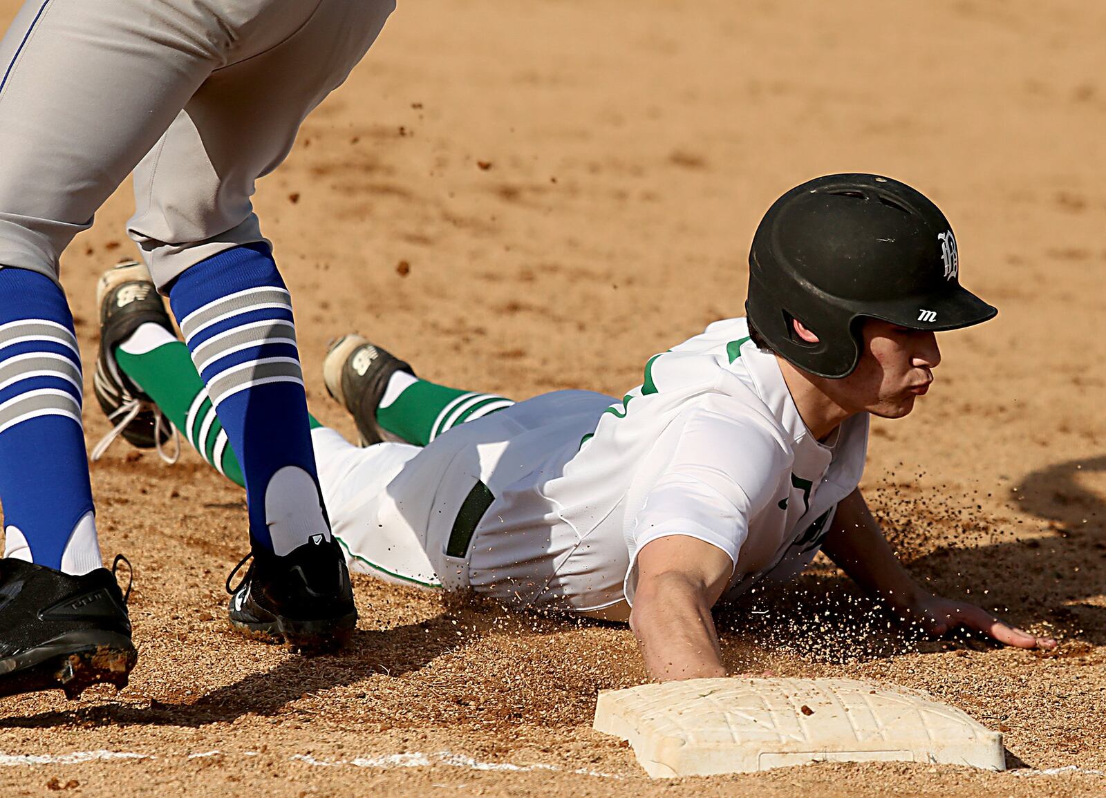 Badin’s Mitchell Ahr dives back to first base to avoid the Defiance pickoff attempt during their game at Alumni Field in Hamilton on Wednesday. CONTRIBUTED PHOTO BY E.L. HUBBARD