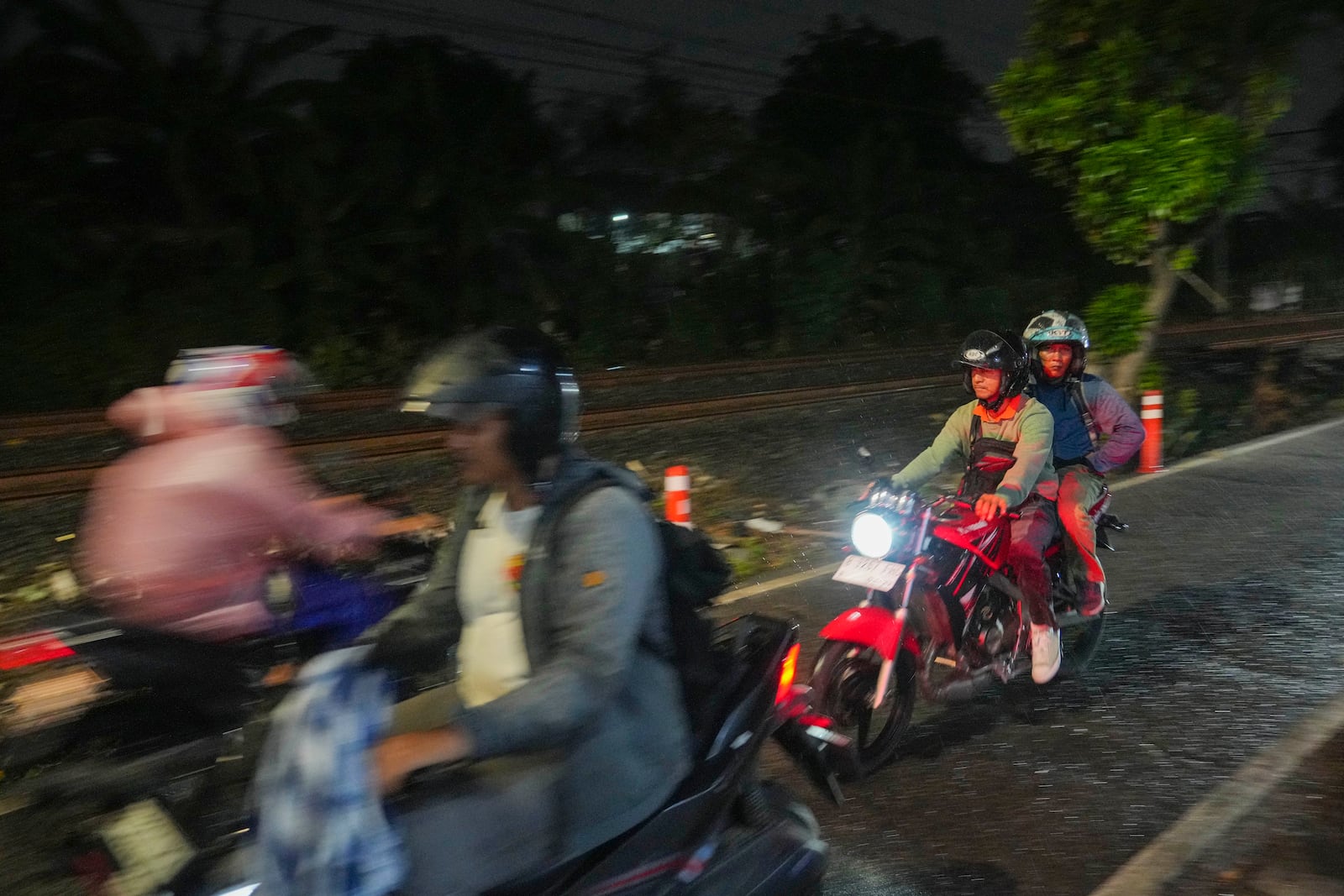 Motorists ride near a railway track where two commuter trains collided in 1987, killing 139 people, in Bintaro, Indonesia, Friday, Oct. 25, 2024. (AP Photo/Tatan Syuflana)