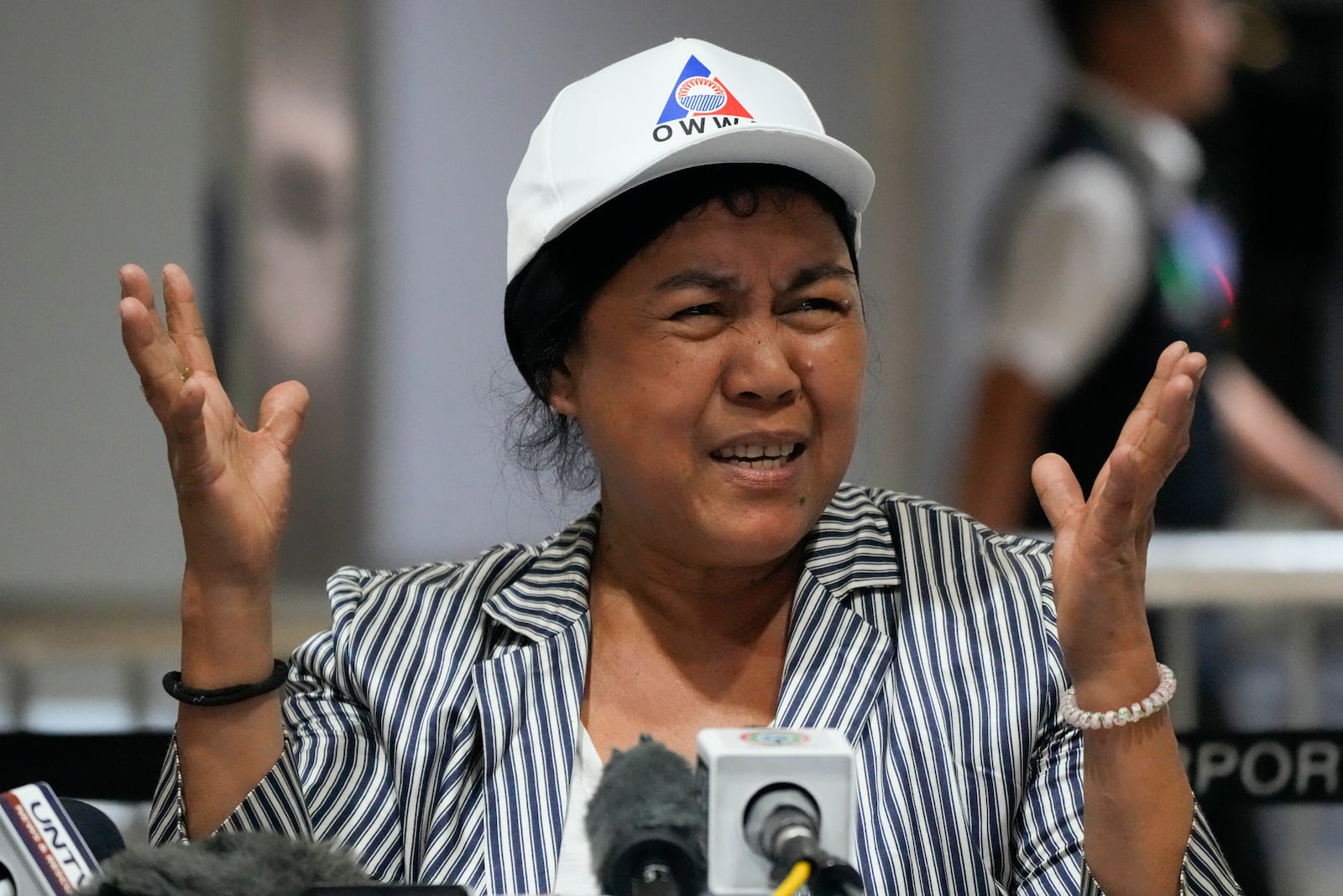 Felicilda Aboc, who has worked for 18 years as a house helper in Lebanon's northern Tripoli city, gestures as she answers questions from reporters upon her arrival at Manila's International Airport, Philippines on Thursday, Oct. 17, 2024. (AP Photo/Aaron Favila)