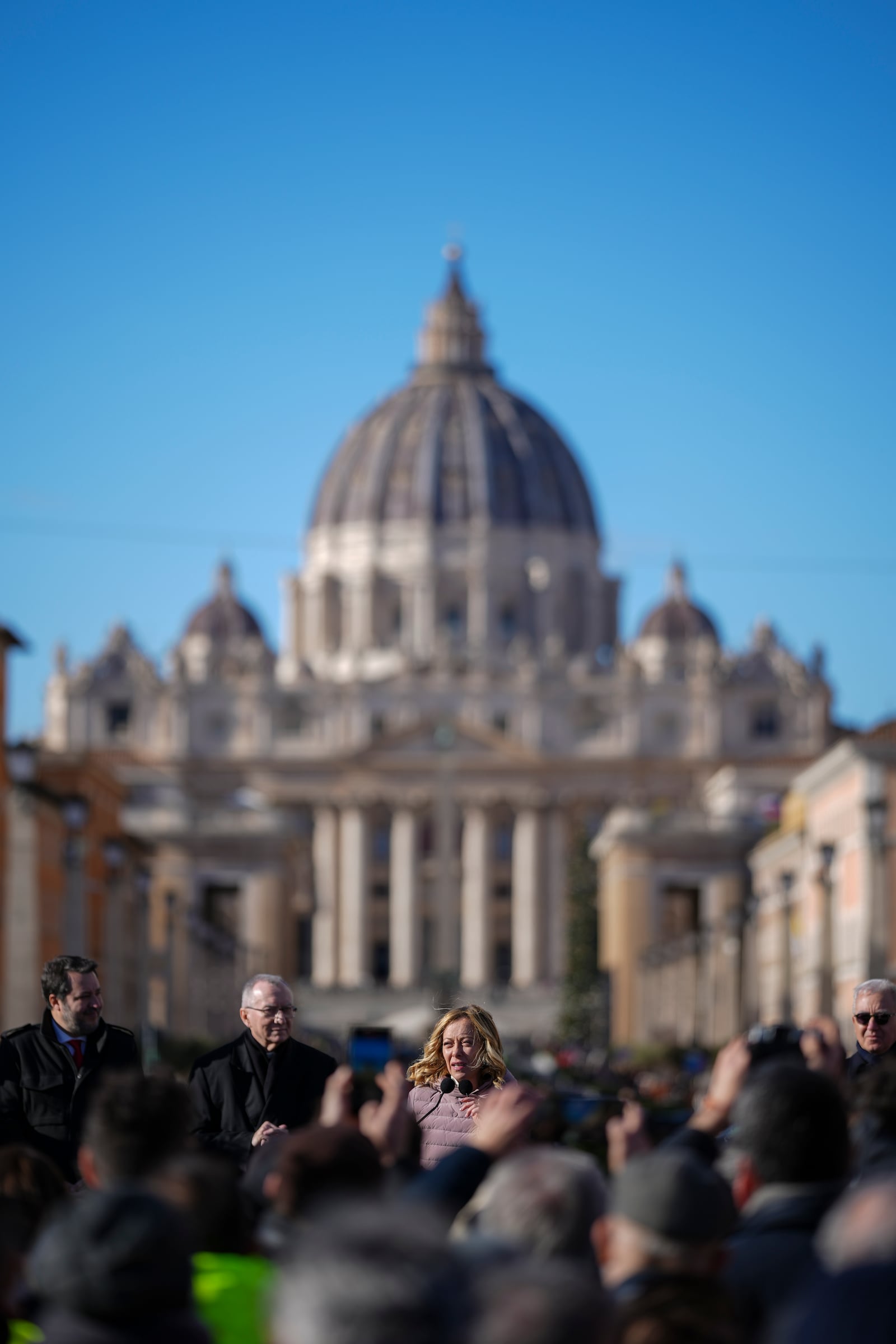 Italian Premier Giorgia Meloni, center, backdropped by St.Peter's Basilica, delivers her speech in Rome, Italy, Monday, Dec. 23, 2024 during the opening ceremony of a new pedestrian area in the nearby of the Vatican, just ahead of the Jubilee Year, an event expected to draw millions of visitors to the Eternal City. (AP Photo/Andrew Medichini)