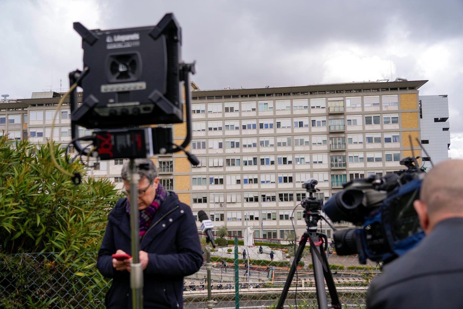 Members of the media take position outside the Agostino Gemelli Polyclinic in Rome, Friday, Feb. 14, 2025, where Pope Francis has been hospitalized to undergo some necessary diagnostic tests and to continue his ongoing treatment for bronchitis. (AP Photo/Gregorio Borgia)